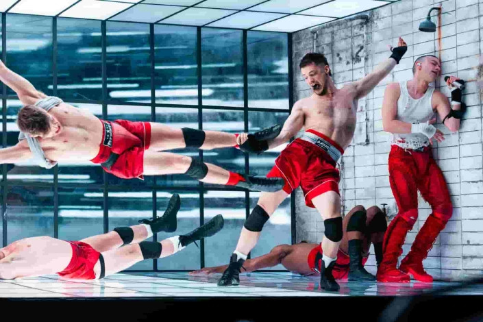 one dancer is "hanging" from the wall, giving the illustion the room has rotated. In this wider shot you can see the second dancer holding him up.