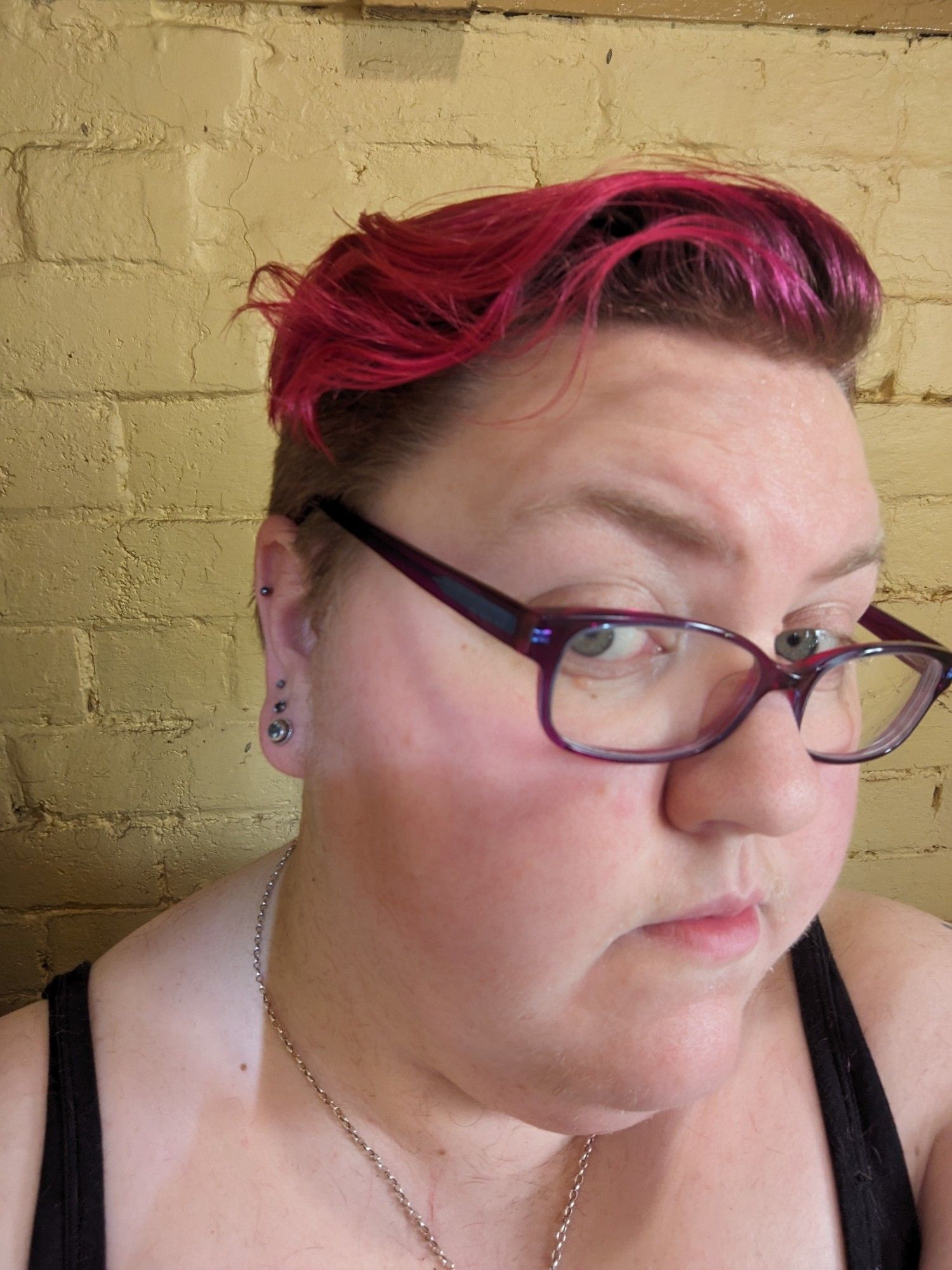 A fat white woman with very short hair, dyed pink on top.