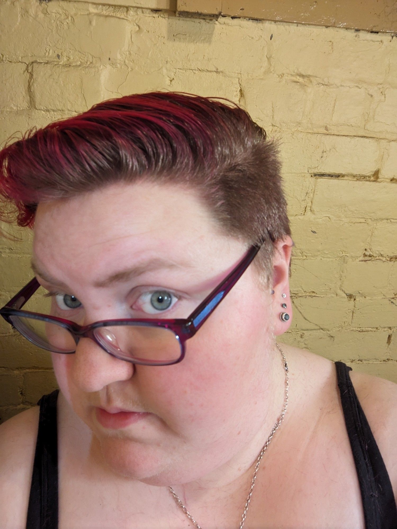 A fat white woman with very short hair, dyed pink on top.