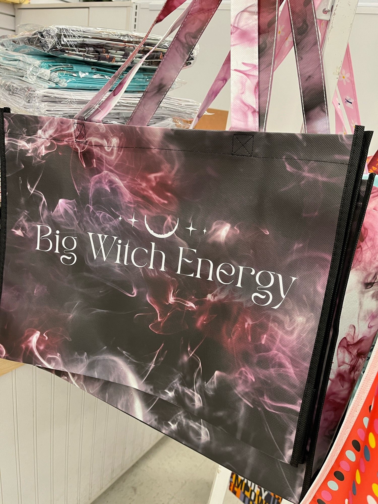 Totebag with the words “Big Witch Energy” on a spooky background.