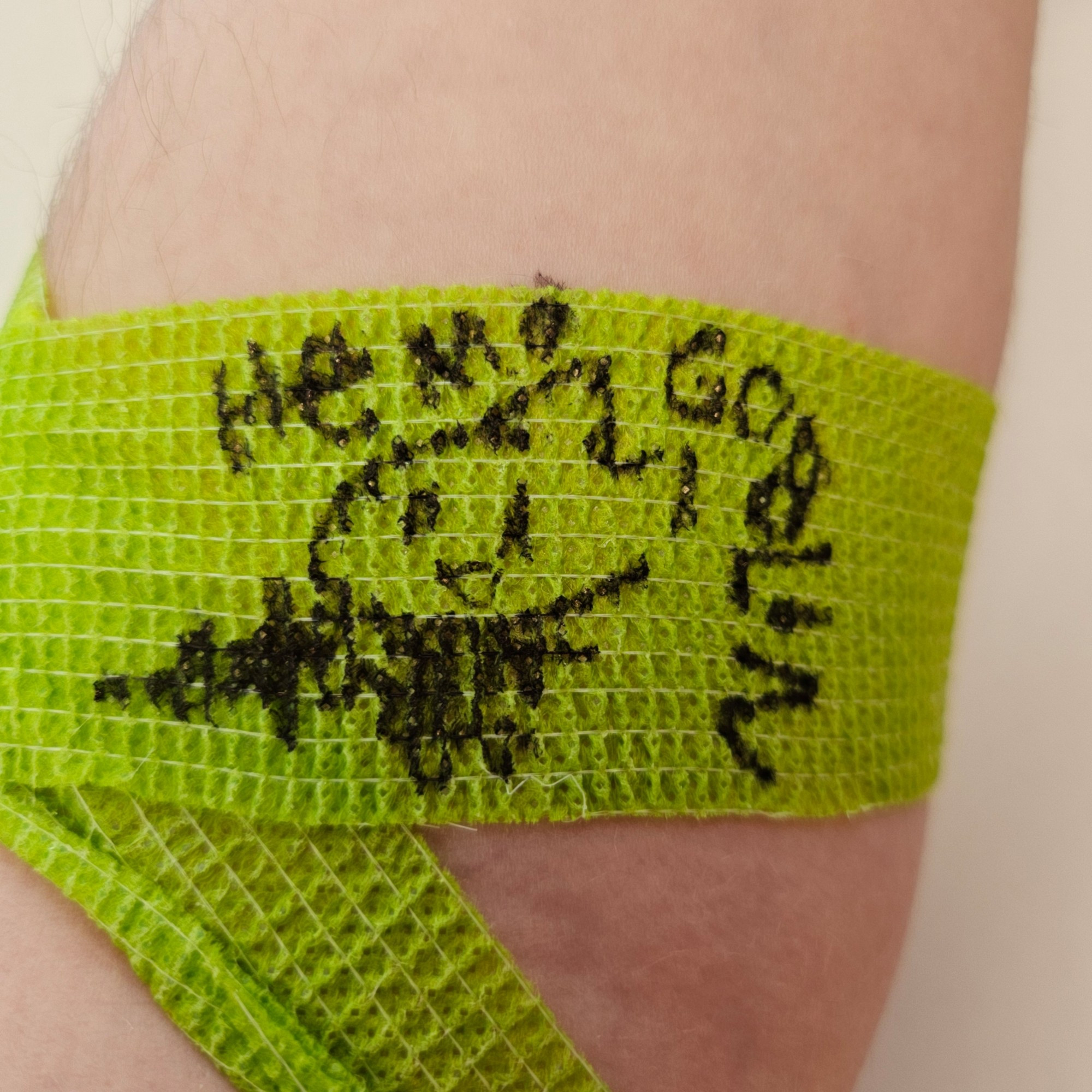 Green bandage on someone's arm after giving blood. I drew a JoCat gobbo with a syringe-- a Hemogoblin!