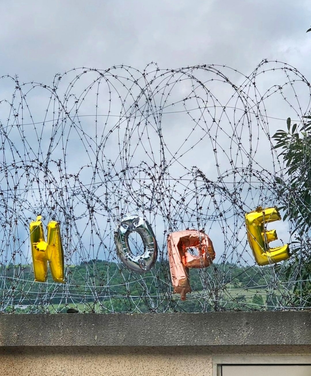 Photography and art. A color photo with four balloons in the form of letters on a wall covered with barbed wire. The balloons in gold, bronze and silver form the word "hope" next to each other. They have been hung in the barbed wire at the top of a street wall.
Info: The artwork and the photo refer to the early parliamentary elections in France, which French President Macron unexpectedly called and in which his party is likely to have suffered major losses. The vote could pave the way for a right-wing populist government. But we must not give up hope.