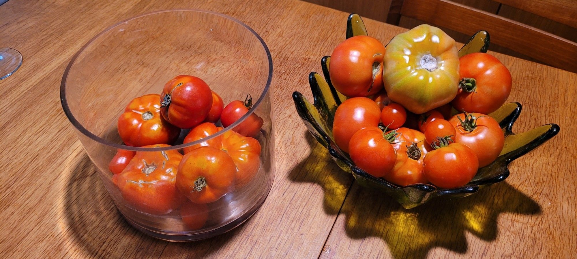 Two containers full of different types of tomatoes: beefsteak, heritage, cocktail.