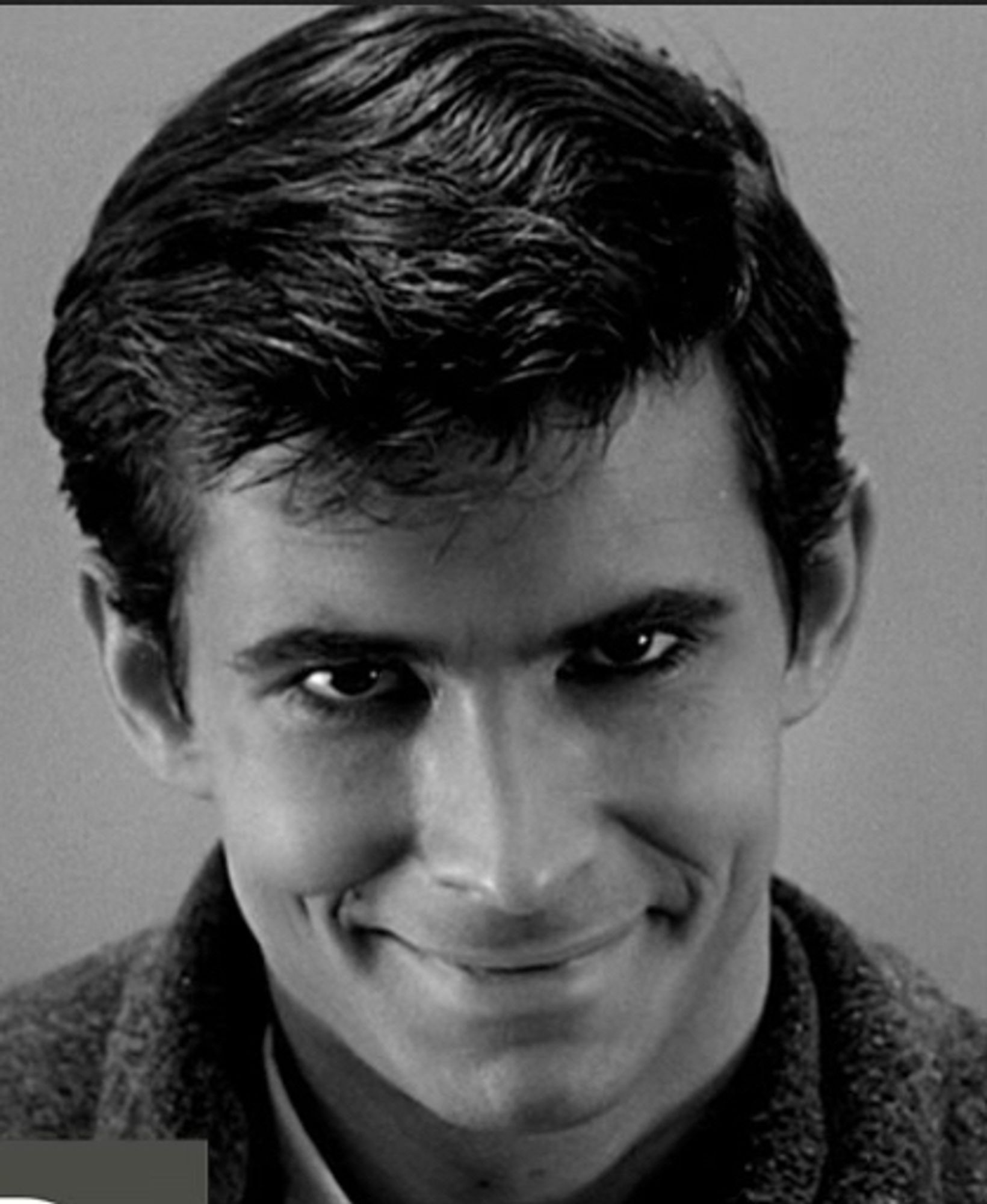 “Psycho” character Norman Bates stares directly at camera with a demented smirk.