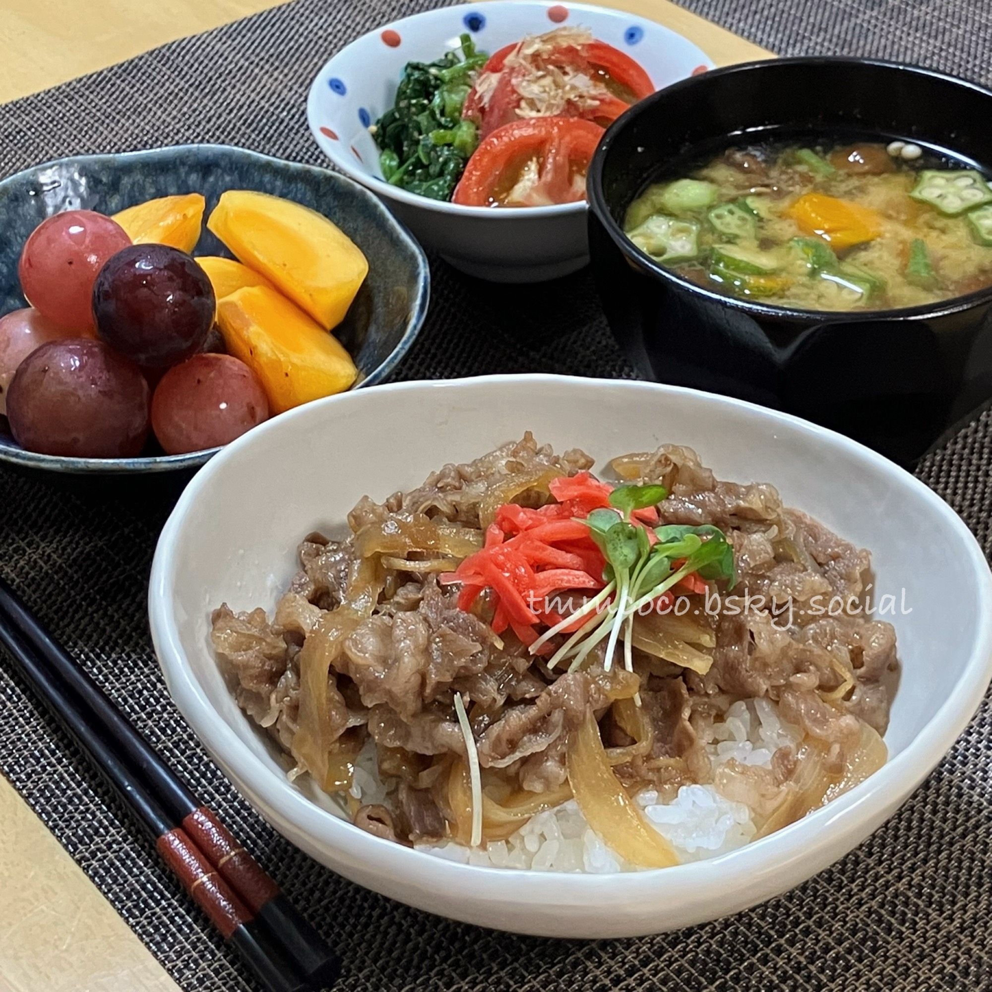 紅しょうがとカイワレをあしらった玉ねぎ多め牛丼、かぼちゃオクラなめこのねばねばお味噌汁、おかかポン酢をかけたトマト、ほうれん草の胡麻醤油和え、種なし柿(たぶん刀根柿)とぶどう(BKシードレス＆クイーンニーナ)を並べた晩の食卓