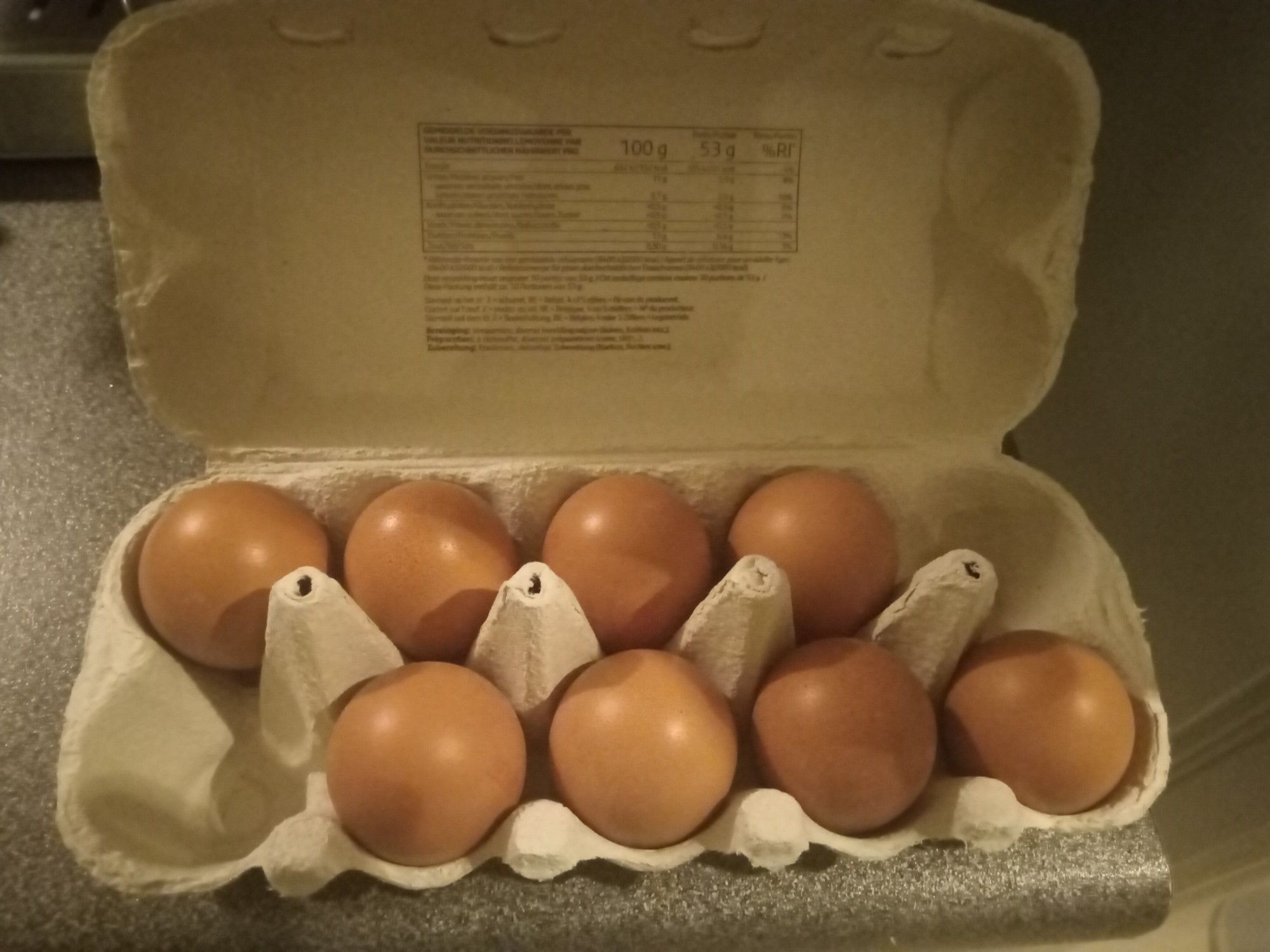 10 eggs in their cardboard box. The top right and the bottom left are missing.