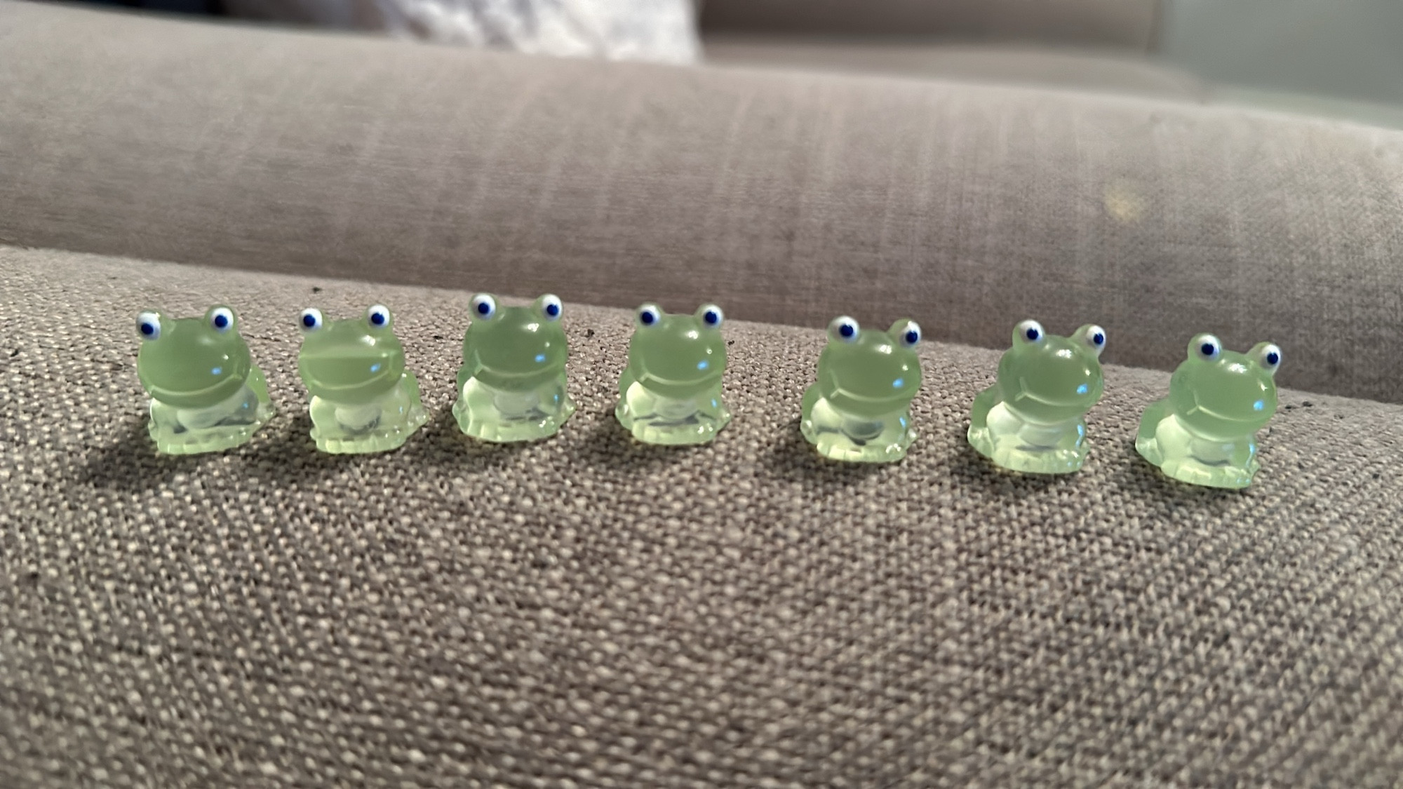 A line of plastic green miniture frogs.