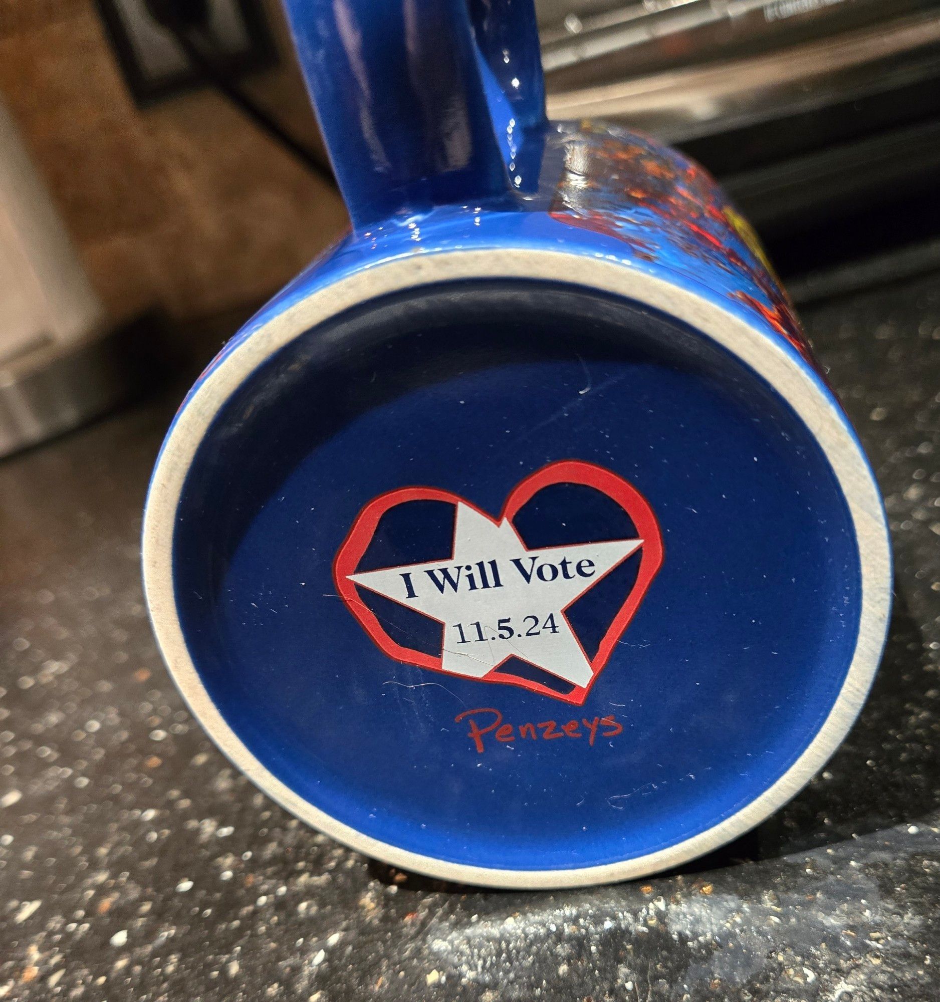 Bottom of coffee mug from Penzey's spices "I will vote 11.5.24" on a white star, inside a red heart.