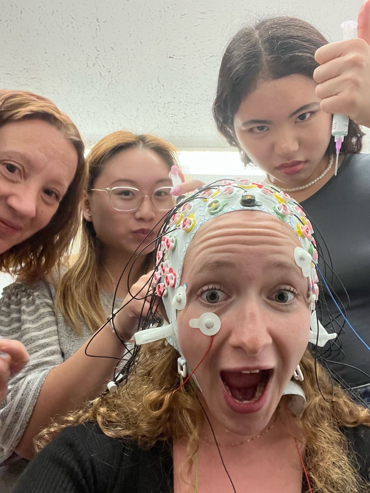 Four women do EEG with goofy faces.