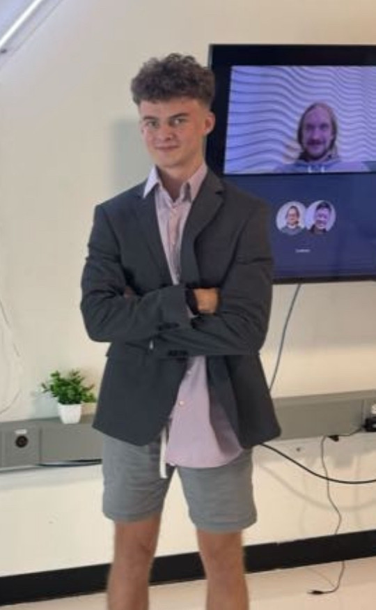 A photo of the DOGE kid known as "big balls"

A Hitler youth dweeb wearing shorts and a sport coat, with late 90's Timberlake hair