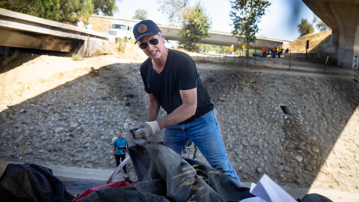 A photo of Gavin Newsom destroying an encampment of unhoused constituents