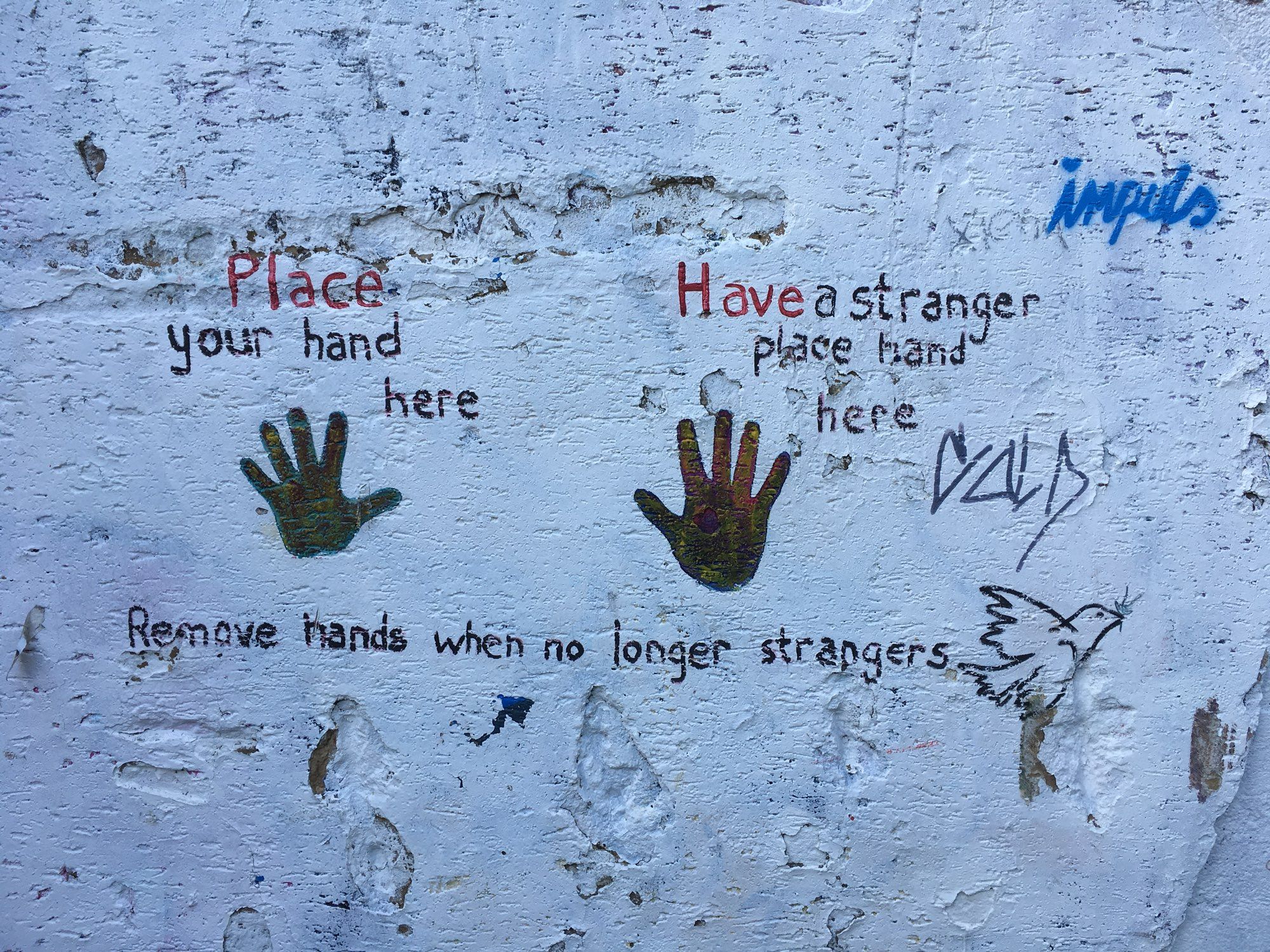 2 handabdrücke auf Mauer. Text über dem linken „Place your hand here“. Über dem rechten „Have a stranger place hand here“.
Darunter unter beiden „Remove hands when no longer strangers“