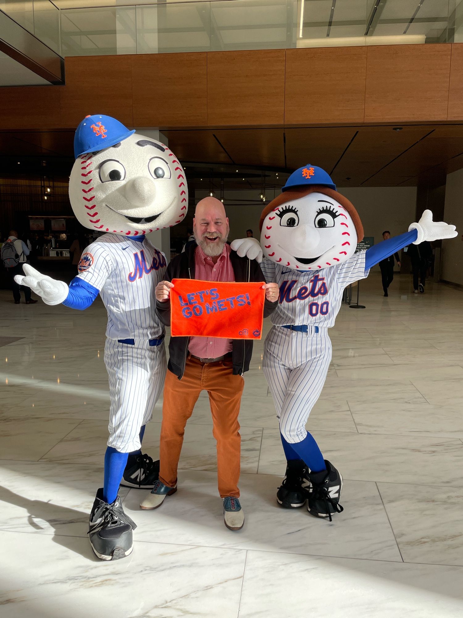 Old fucker flanked by baseball-headed mascots