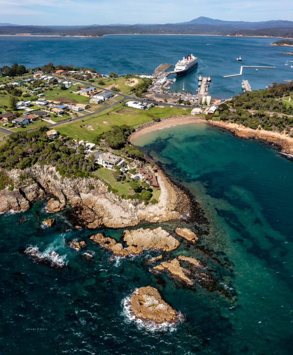 Aerial image of Eden, NSW - with the cruise ship Disney Wonder docked in Twofold Bay.