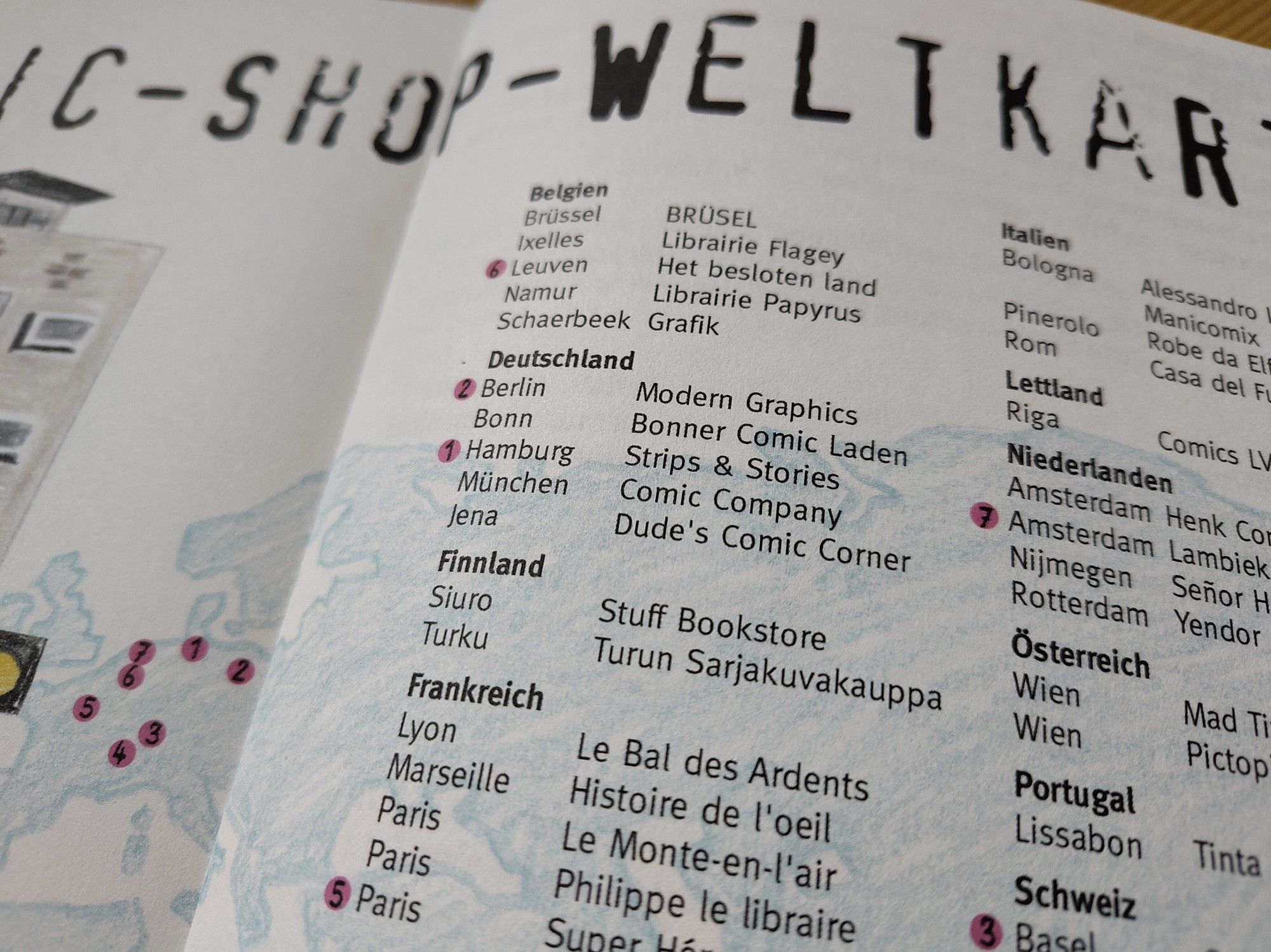 Ausschnitt einer Doppelseite aus dem Magazin Strapazin mit einer Liste von Comicläden in verschiedenen Ländern