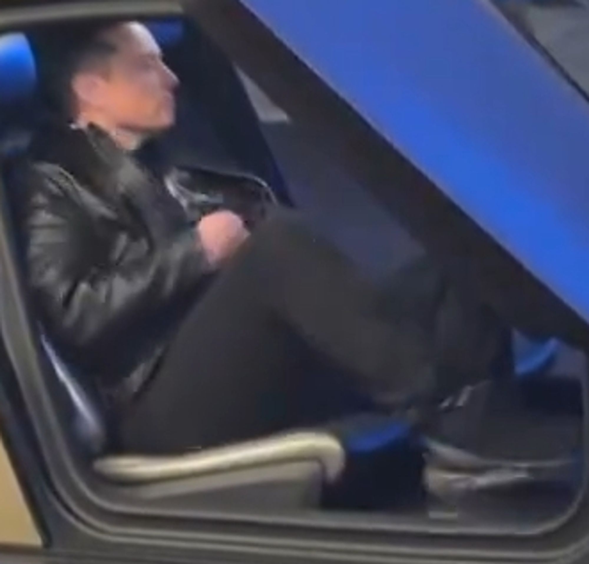 A still from the video showing Elon Musk sitting in the "Cybercab". His seat cushion is approximately six inches off of the floor of the vehicle, forcing Musk to sit with his knees poking up.