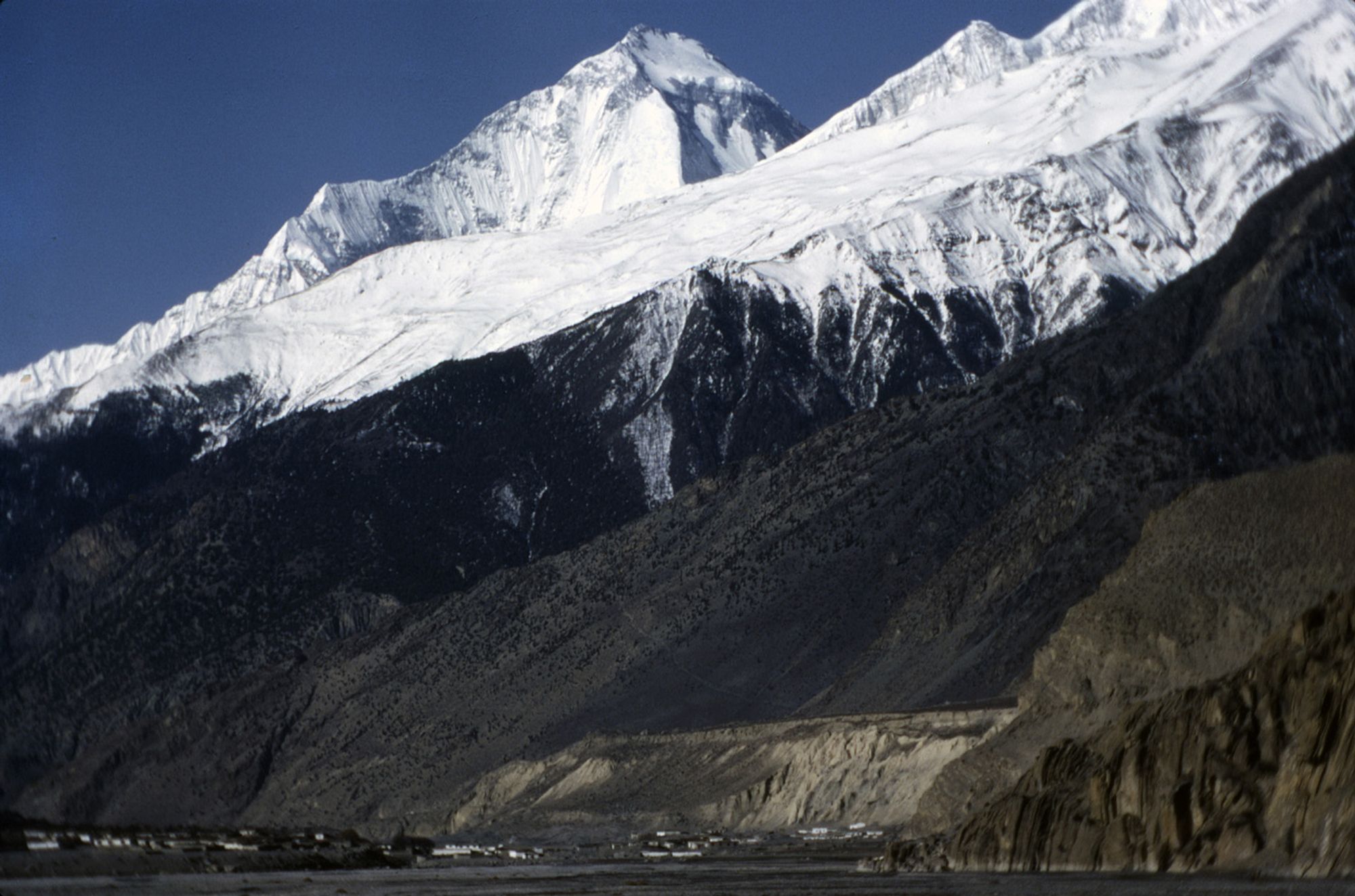 Dhaulagiri peak (8,167 m) rising above the village of Marpha (2,566 m) in the Kali Gandaki river valley in western Nepal, 1983.