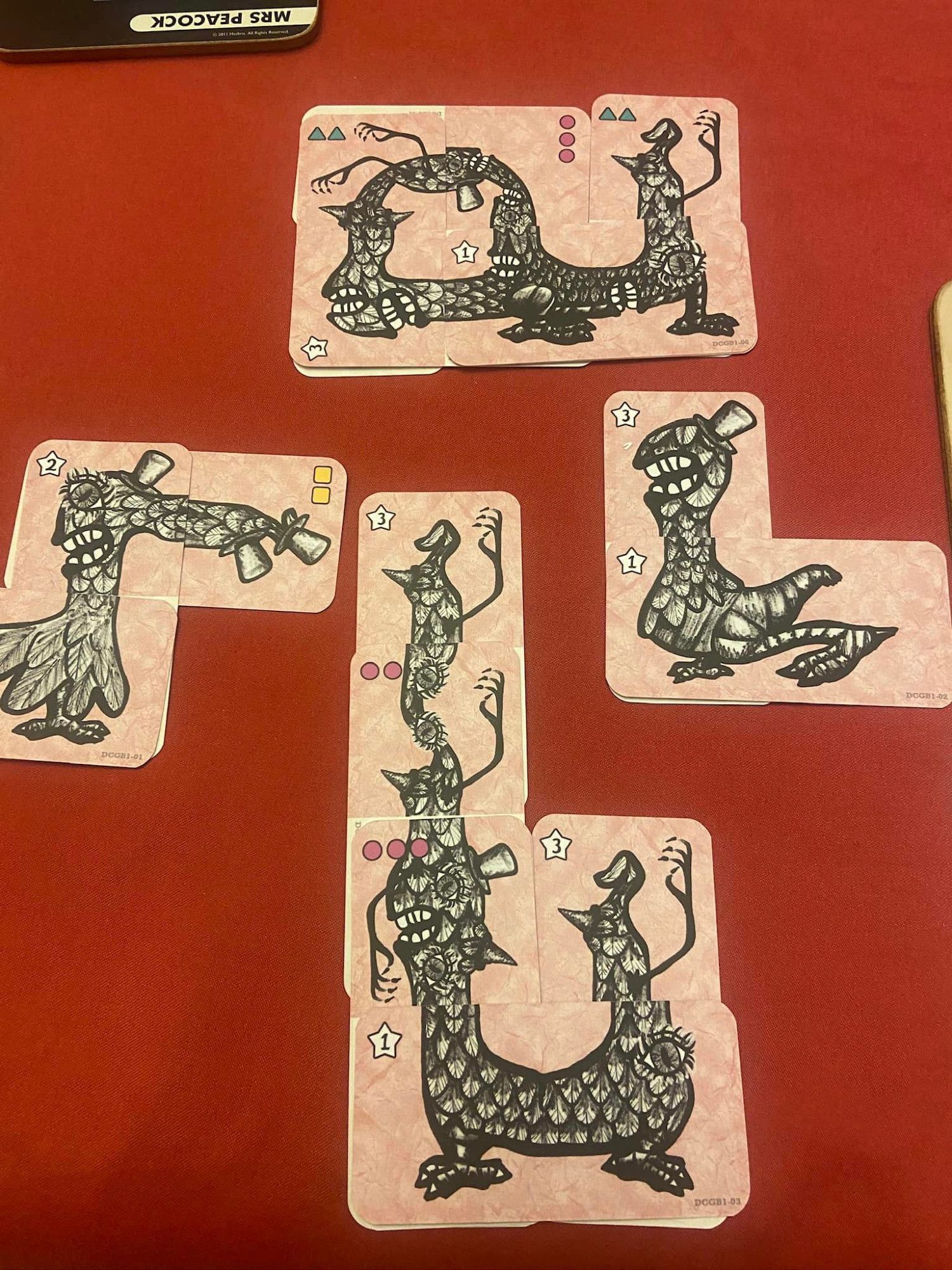 Image is of various creatures that have been assembled. They are assembled using cards that combine to create weird  creations full of loops, and mouths/hands/eyes/hats in odd places. They weren't assembled within an actual game, but they could have been. They have costs in the corners of cards.