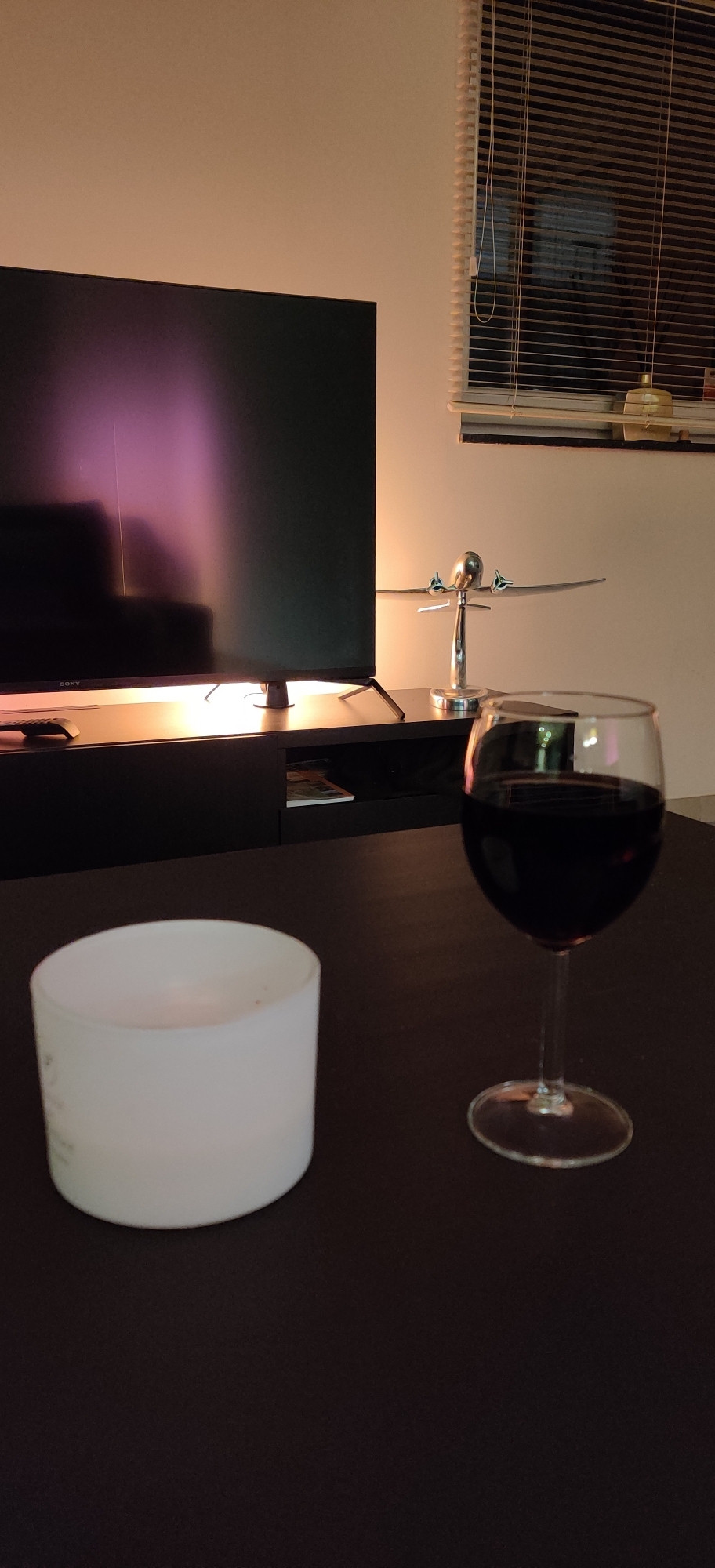 Un verre de verre sur une table basse... Une bougie et un peu de déco en arrière plan