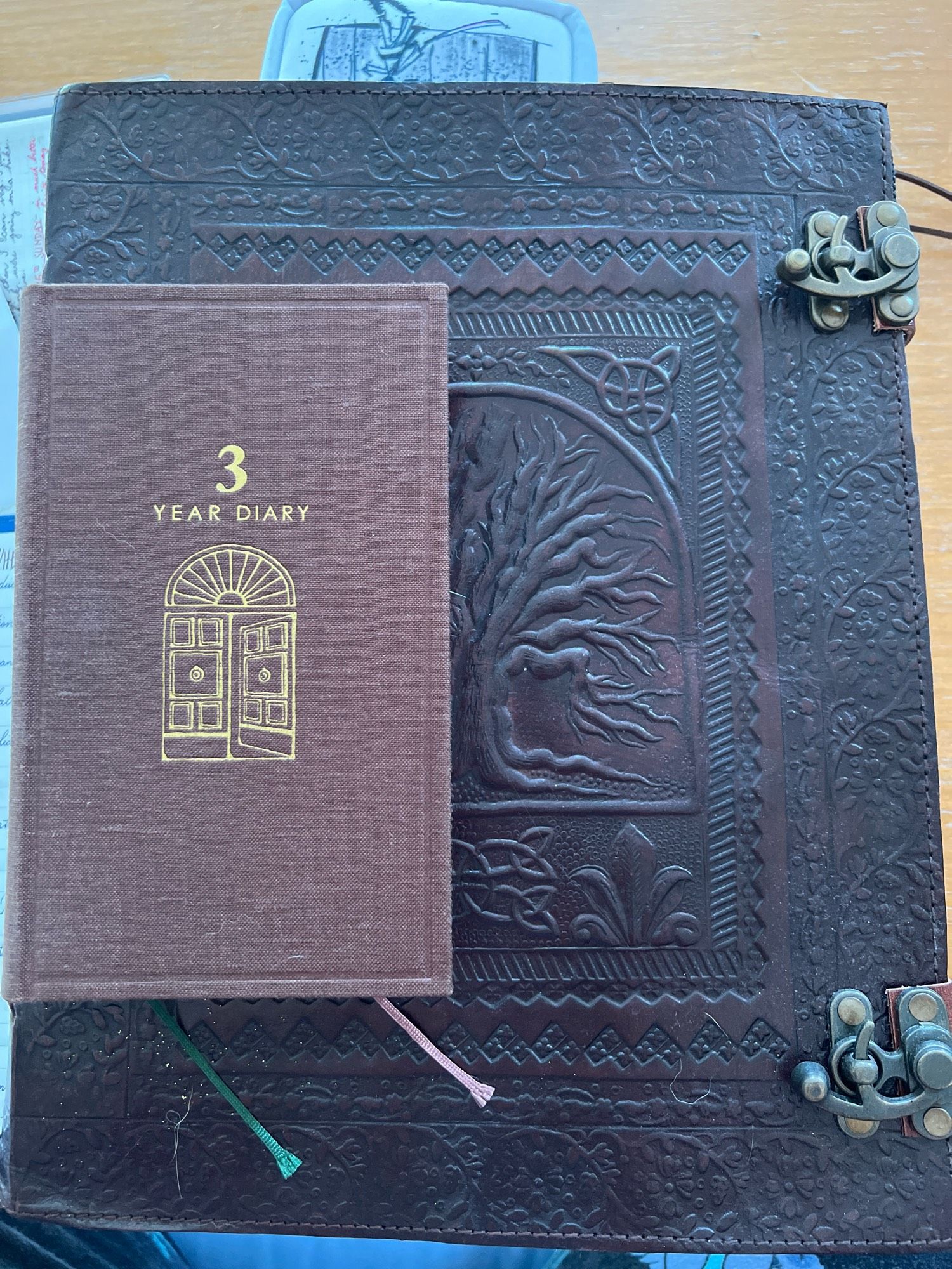 A large leather bound journal shown with Midori 3 year diary for scale