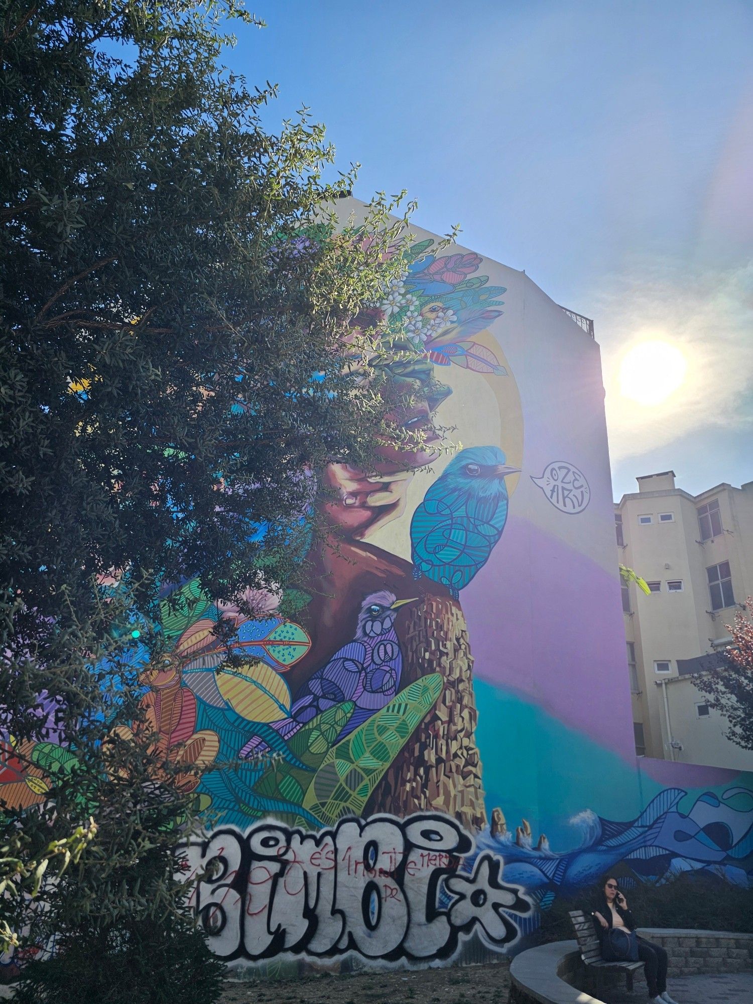 Colorful mural and sun appearing behind