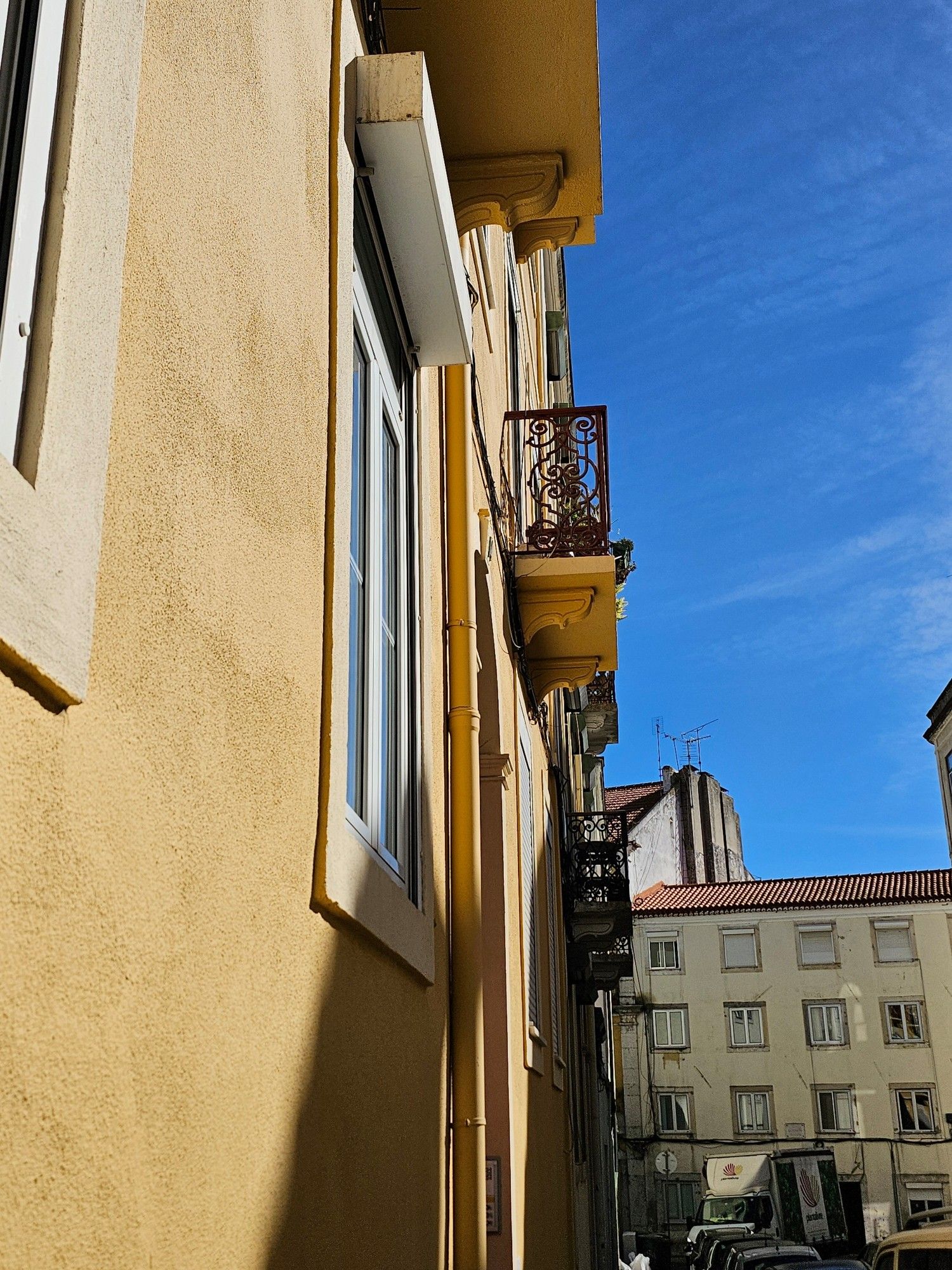 Wrought iron balconies on a yellow house