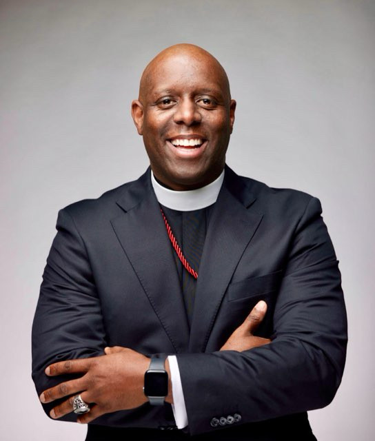 Photo of Rev. Washington smiling with his arms crossed.
