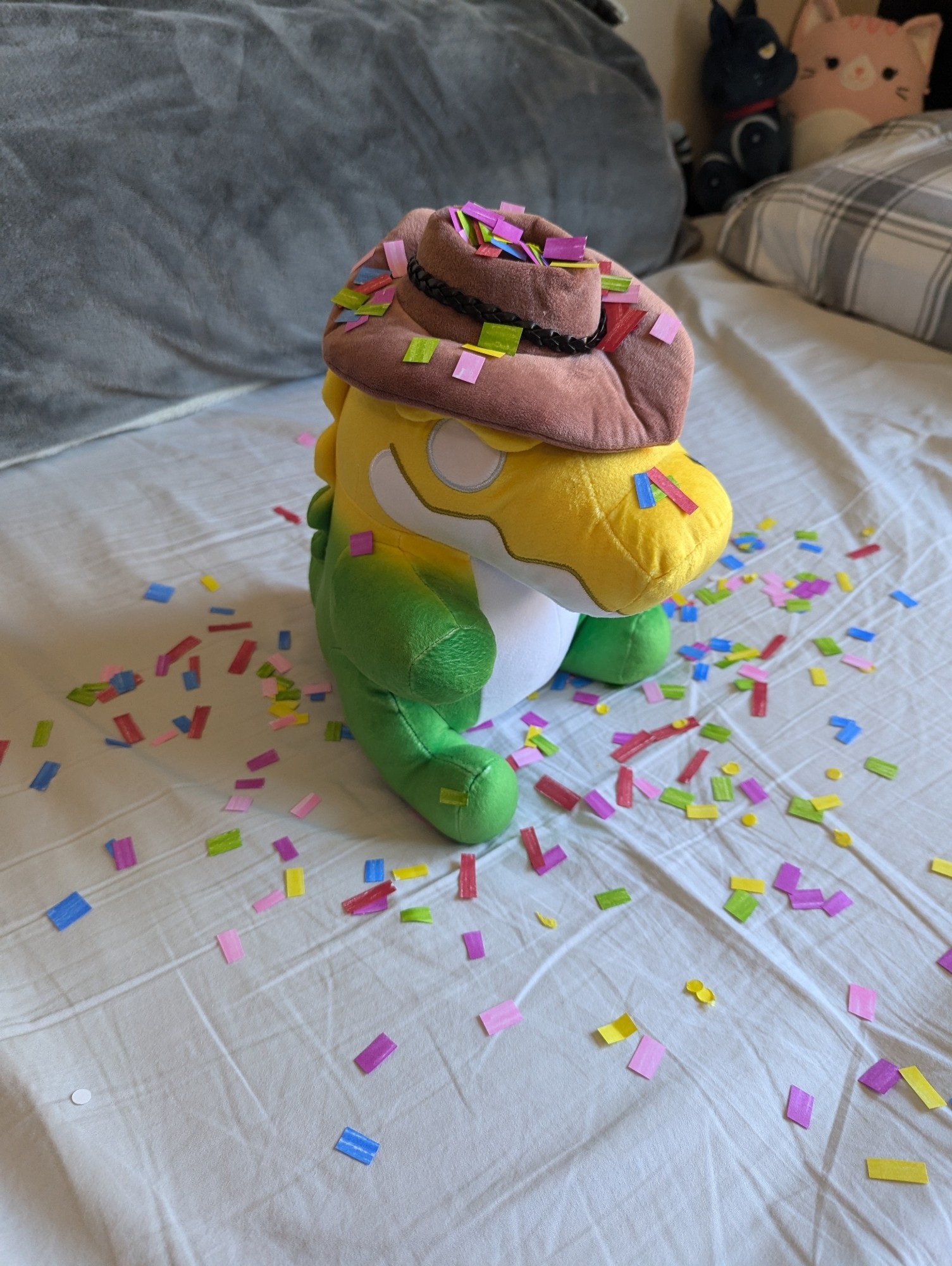 Picture of an Amazing Digital Circus Gummigoo Plush sitting in the middle of a small explosion of confetti