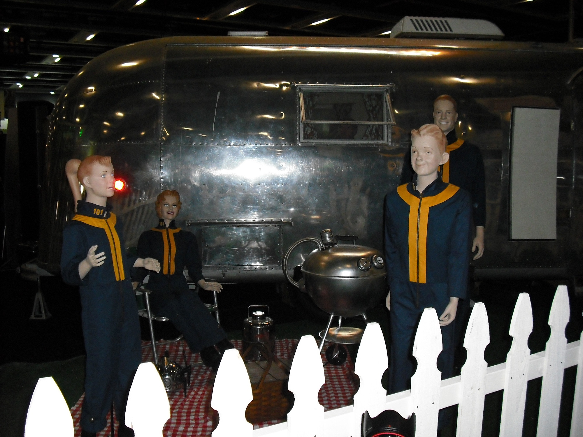 Fallout booth - a vintage camper surrounded by mannequins in Vault Dweller suits.