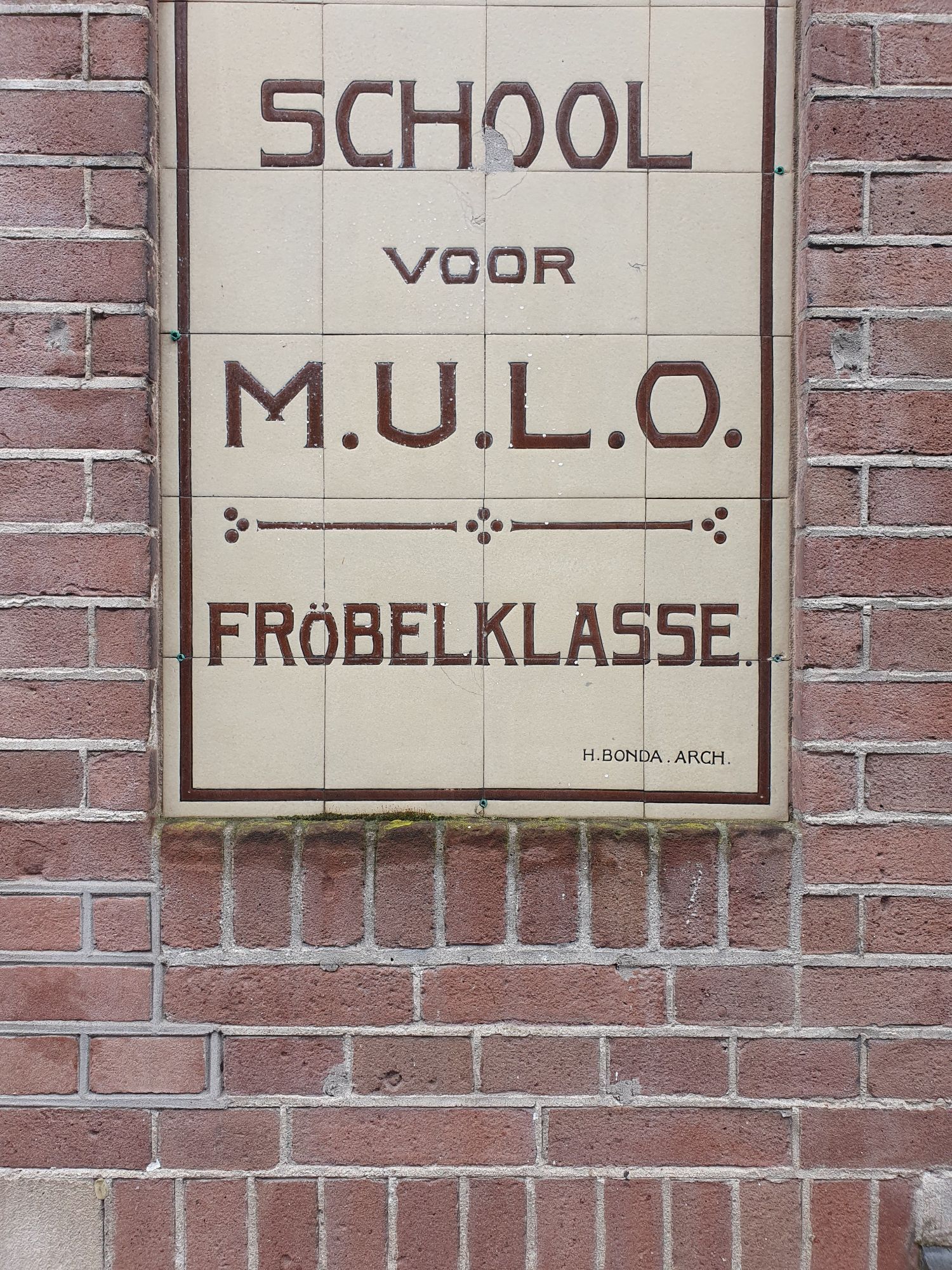 Tegelborf op een bakstenen muur. School voor mulo fröbelklasse