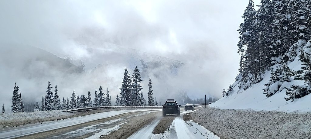 Driving over Berthoud pass, snow, mountains, and clouds.