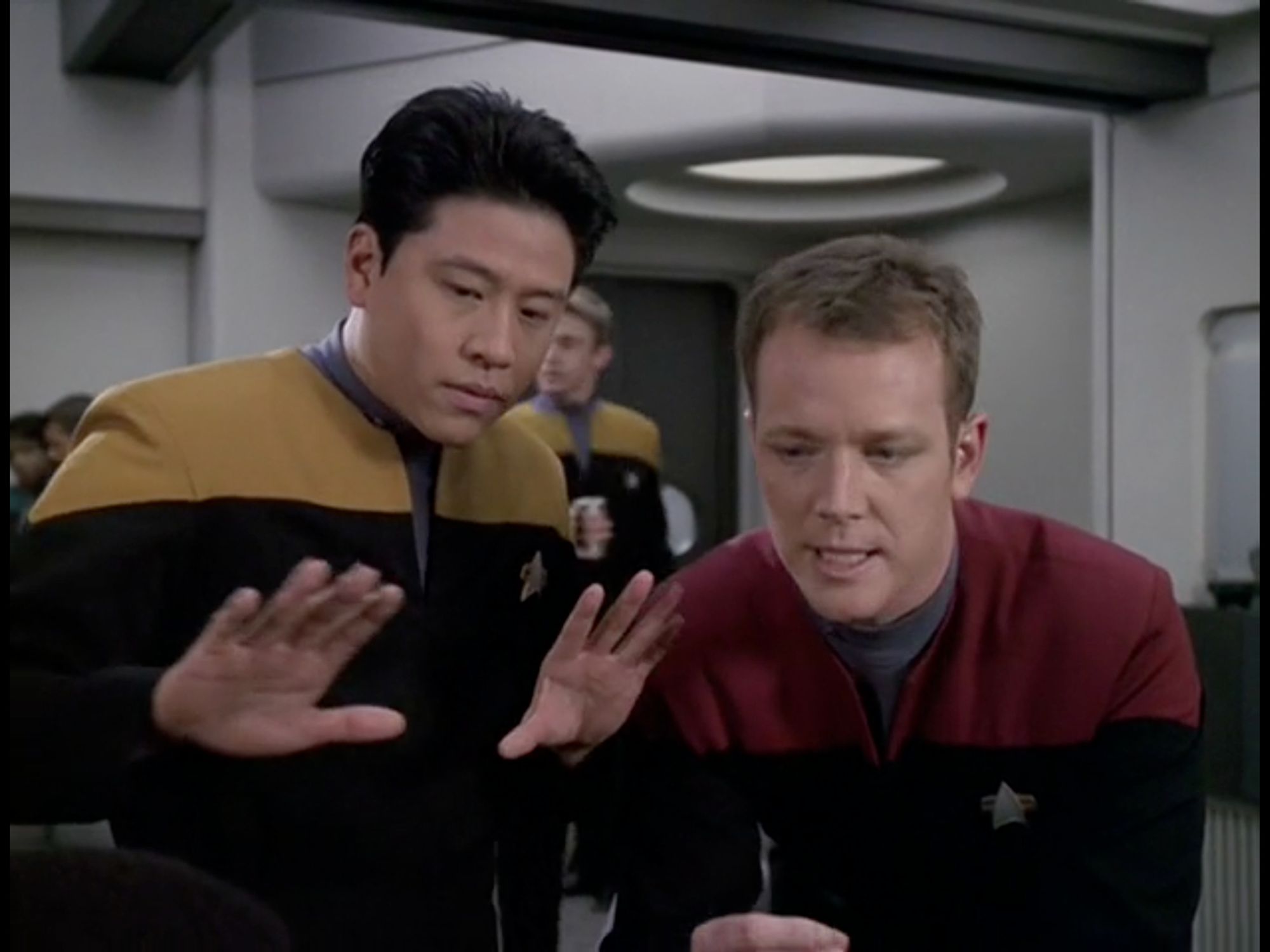 Harry Kim and Tom Paris are side by side. Harry has his hands in front of him, palms facing out, his shoulders slightly hunched, as he looks down. Tom is hunched over, like he's talking to someone below him, and he's making a strange face, with his eyes half closed and his mouth somewhat open.

From Star Trek Voyager, Season 6, Episode 11, "Fair Haven"