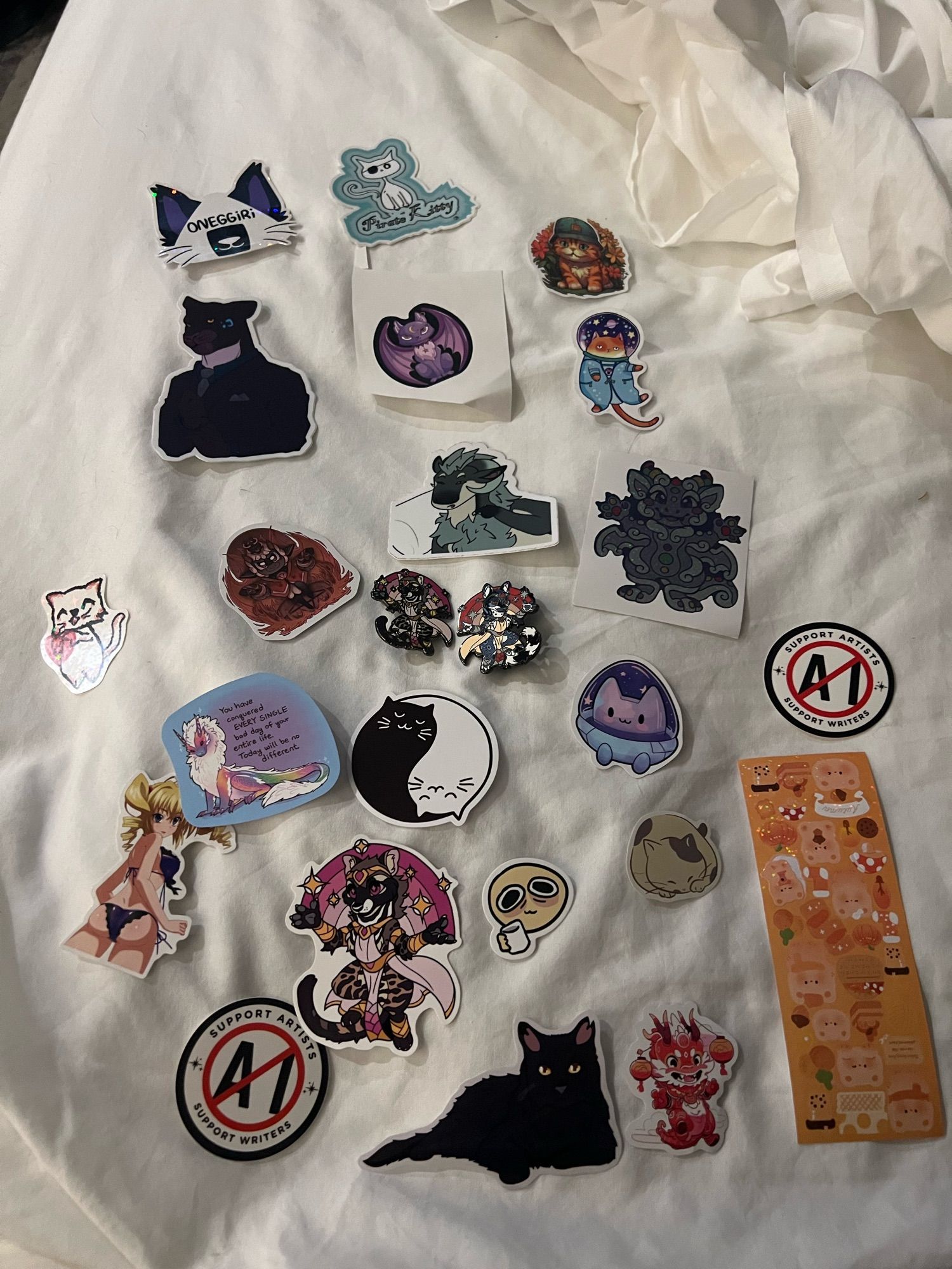 A variety of playful (mostly cat) stickers on a bed