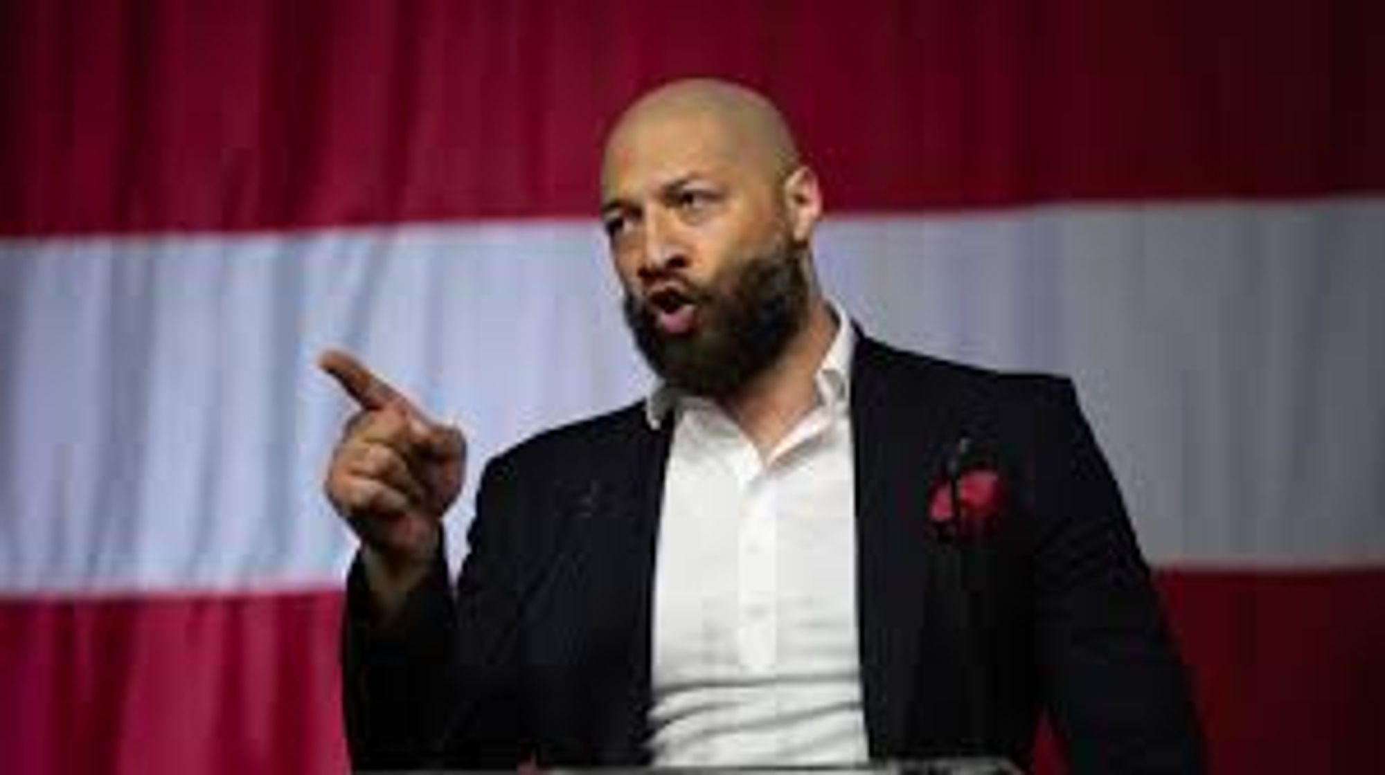 Photo of a bald, bearded black man pointing.