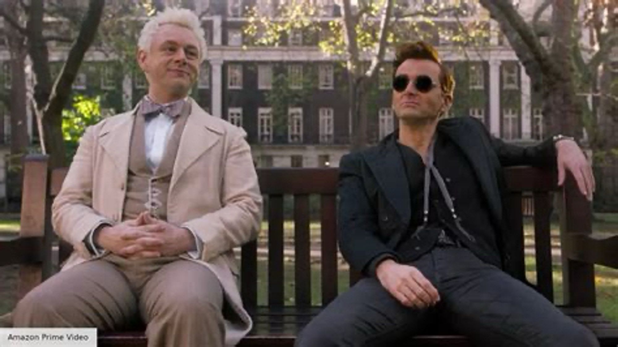 Crowley, right, and Aziraphael, left. The sartorial opposites. Crowley is dressed all in black with what looks to be a snake tie, sunglasses and a spiky red ‘do. Aziraphael is dressed like a gentleman from the 50s, all in creams and beige. He has a bow tie and spiky white hair.