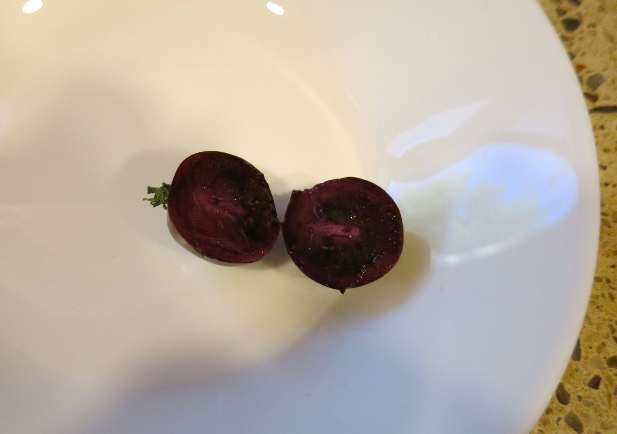 A tomato cut open to reveal purple guts.