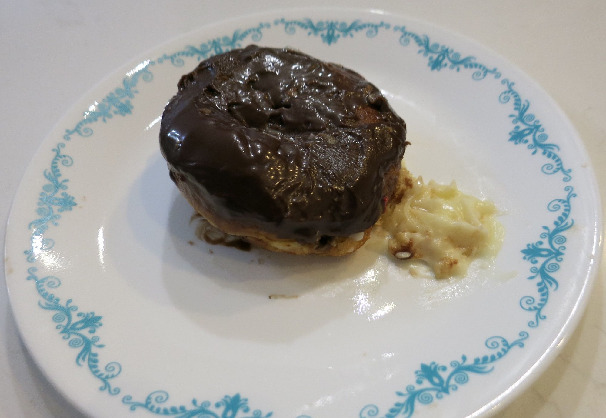 A bismark cream donut on a plate with the cream splooted out at one side. It is not an MRI.