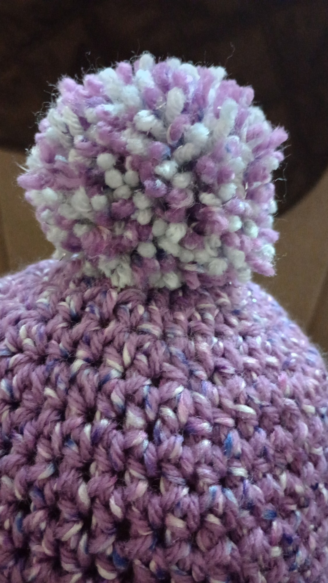 Crochet pom pom atop a hat.