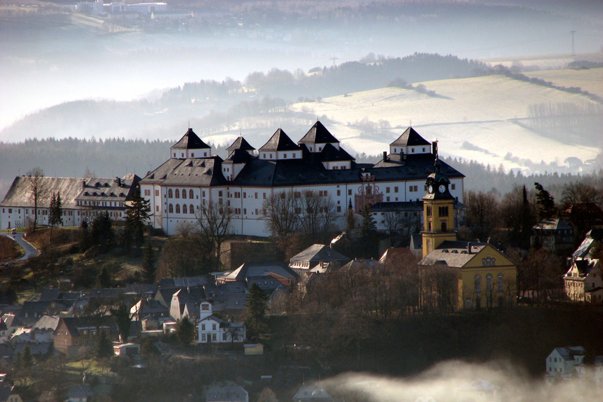 Schloß Augustusburg mit Teleobjektiv aufgenommen, dahinter Berge.