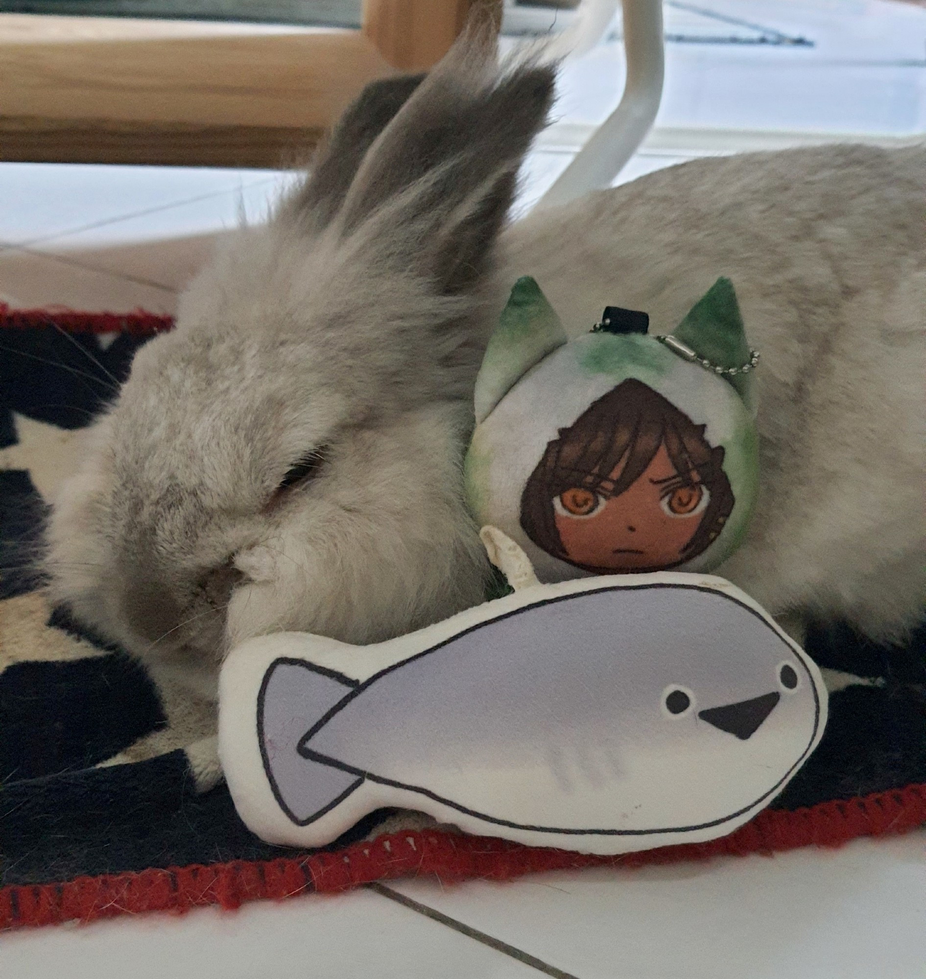 a rabbit sleeping with a sunshower outis and sacabambaspis plush