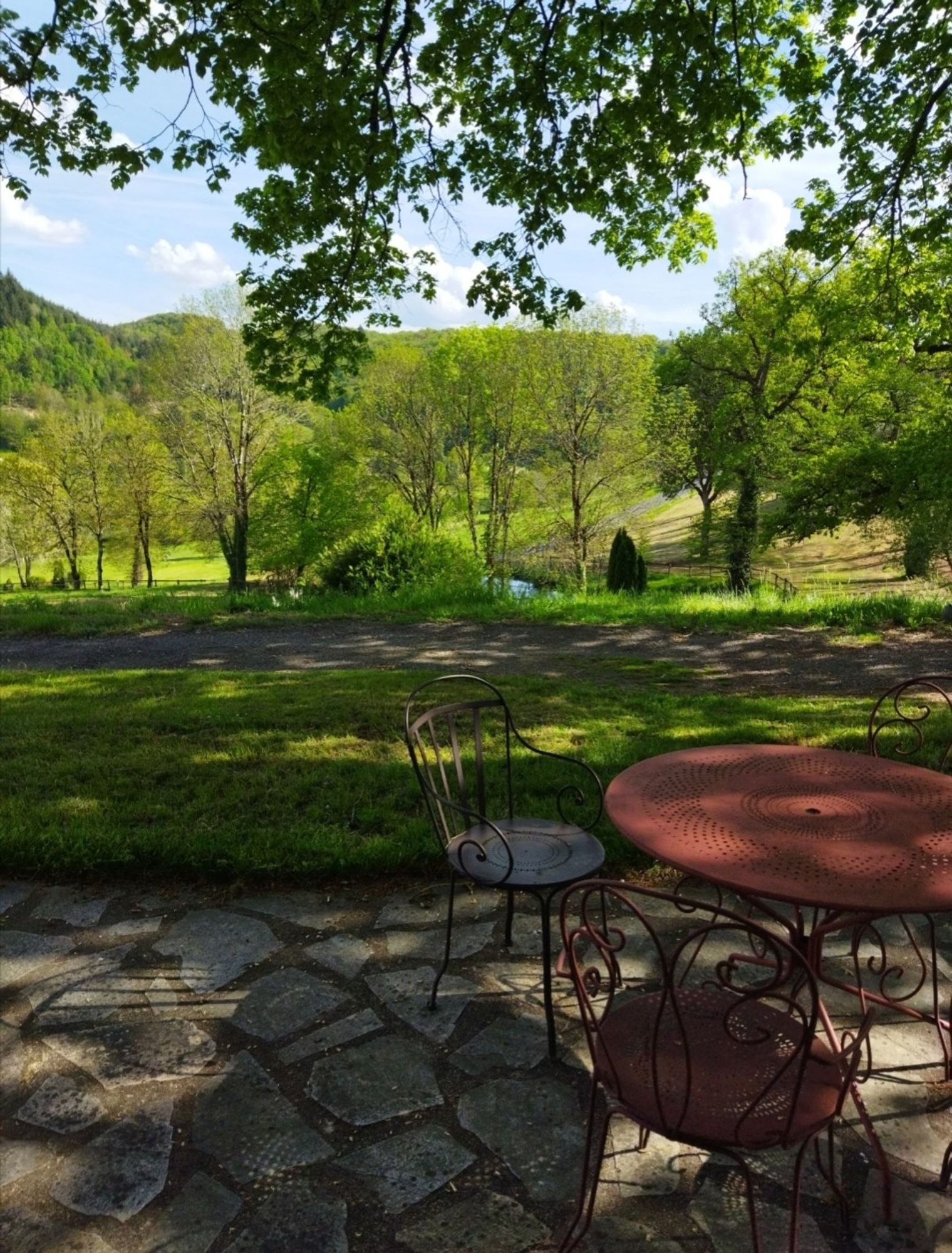 Un guéridon, deux chaises 
Vue sur la campagne bien verte