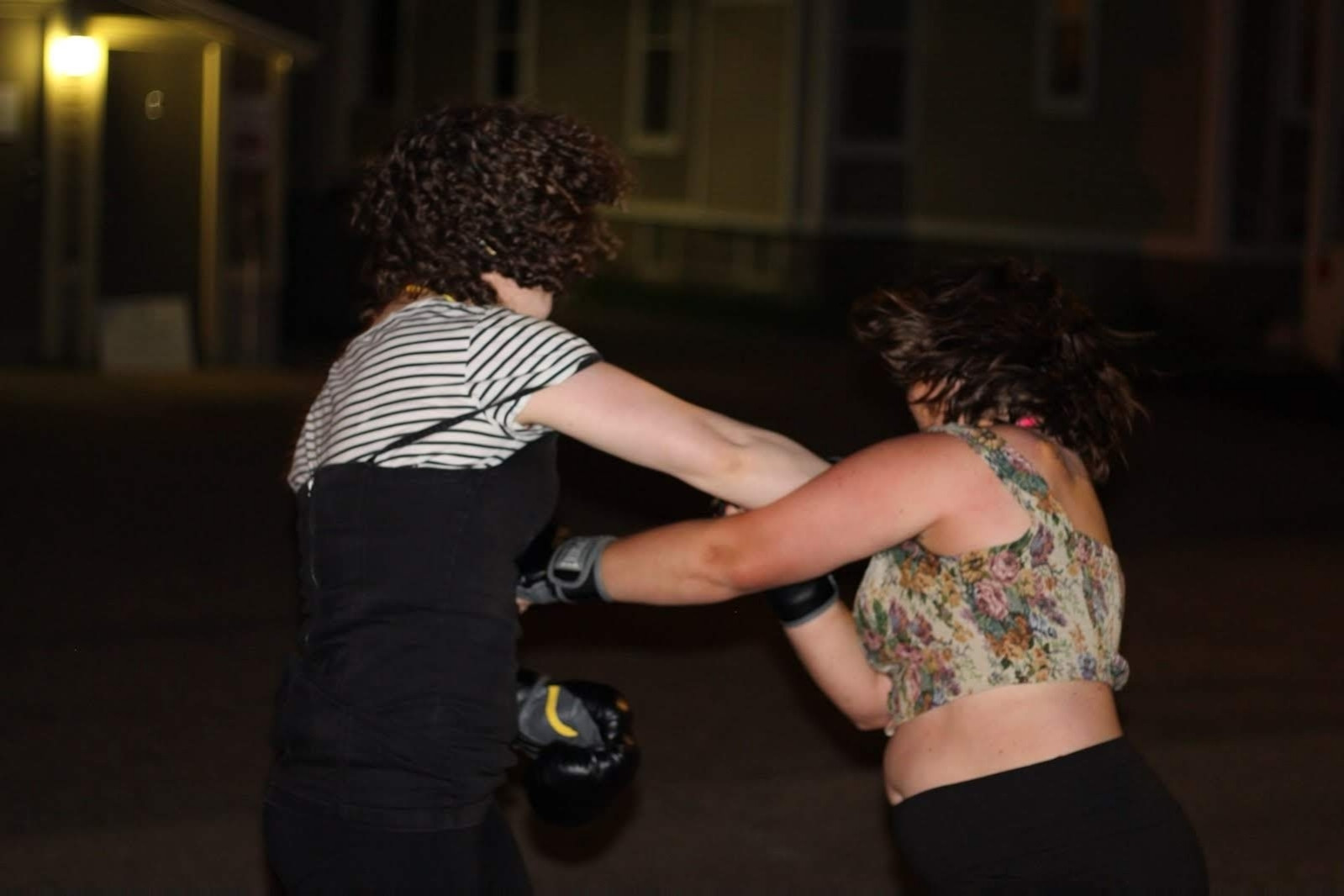 A photo of Mana punching a stranger (now her ex) in the chest with boxing gloves in an alleyway.