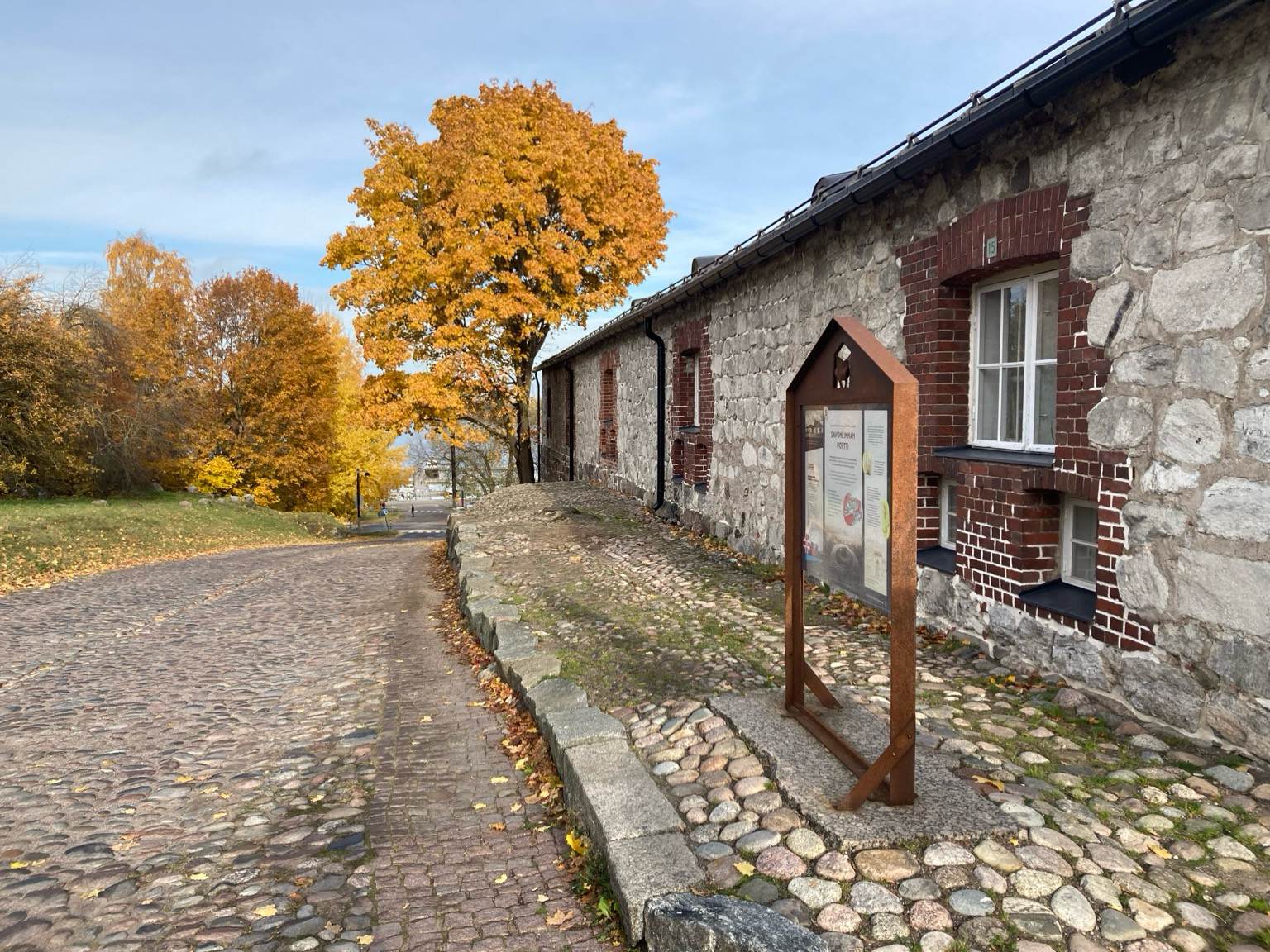 Kuva linnoituksen laelta alas vievälle tielle joka kulkee museorakennuksen vierestä