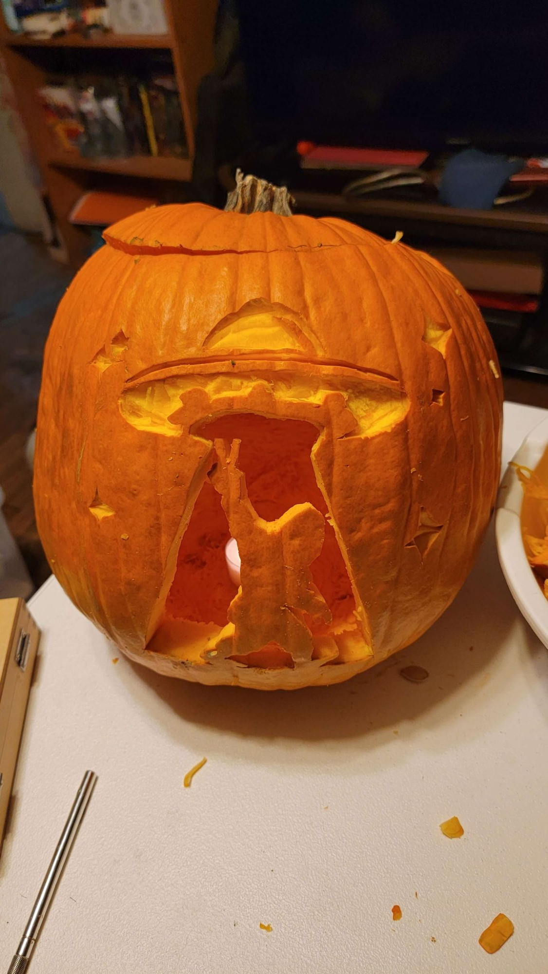 A pumpkin with a UFO carved out and Sasquatch in the beam throwing a peace sign.