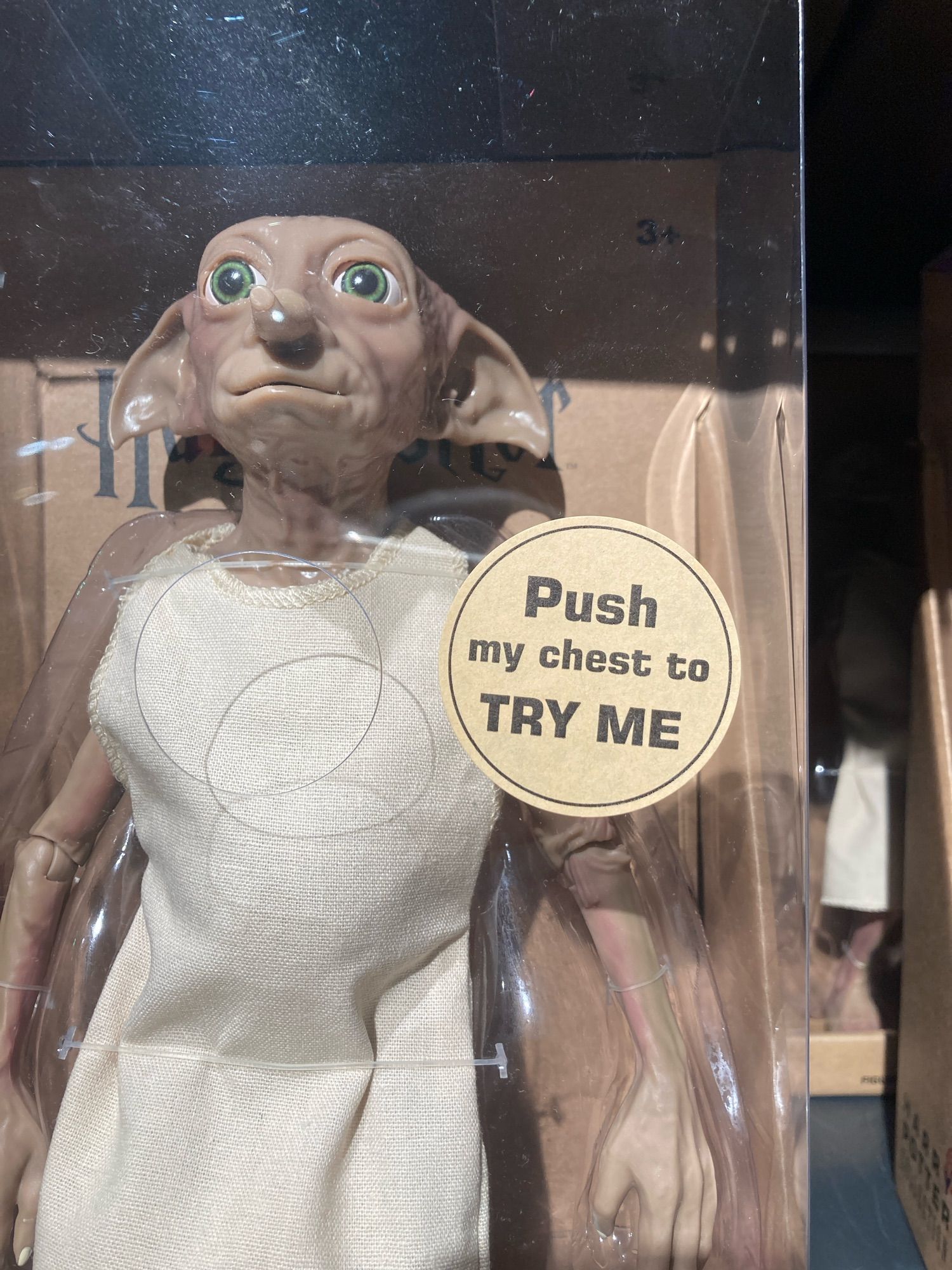 it’s a toy of gollum or whoever from harry potter w a hole cut in the plastic & a sticker says Push my chest to TRY ME