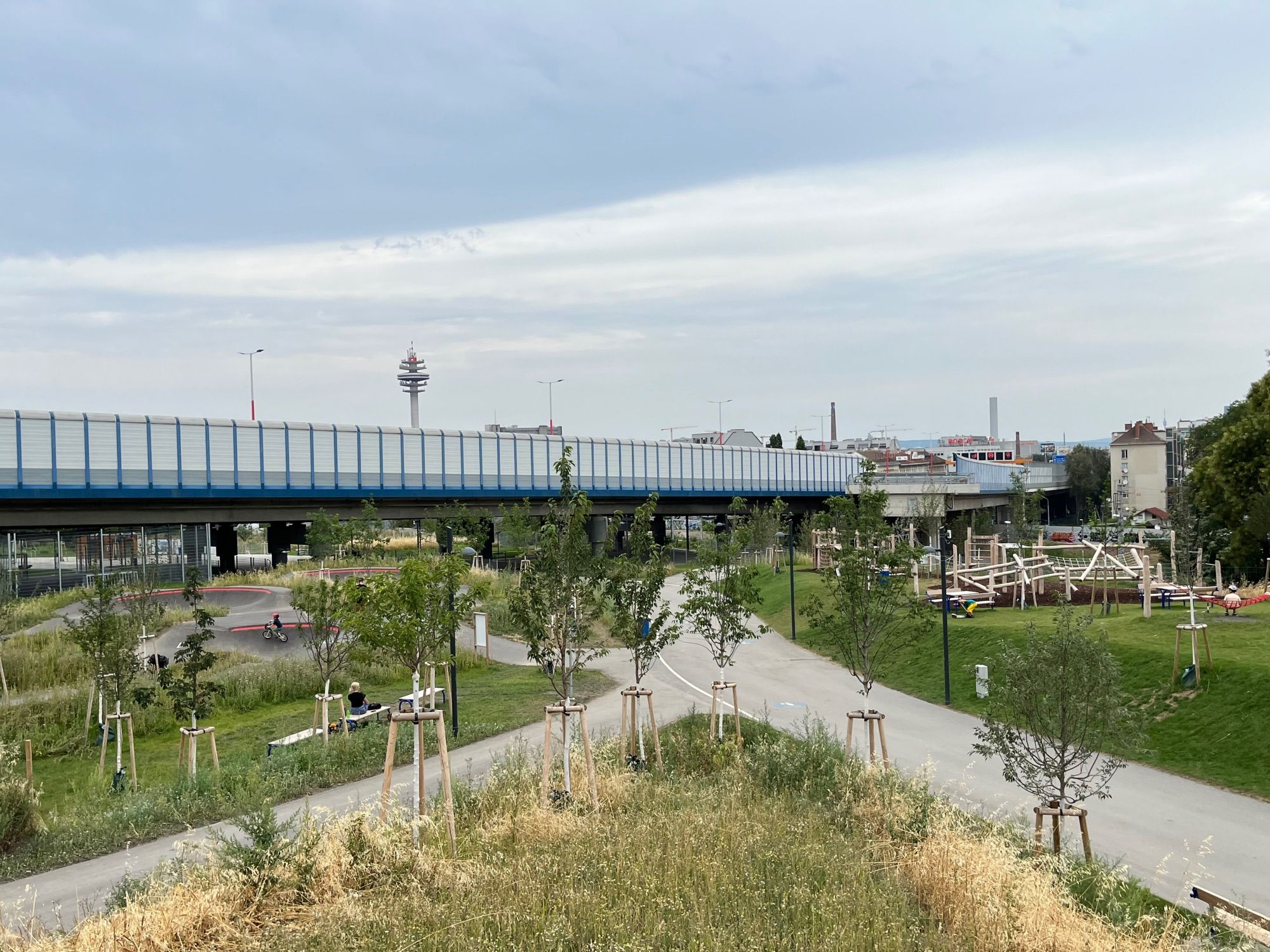 View of the former highway exit ramp that was turned into a playground and sports area, with plenty of new trees