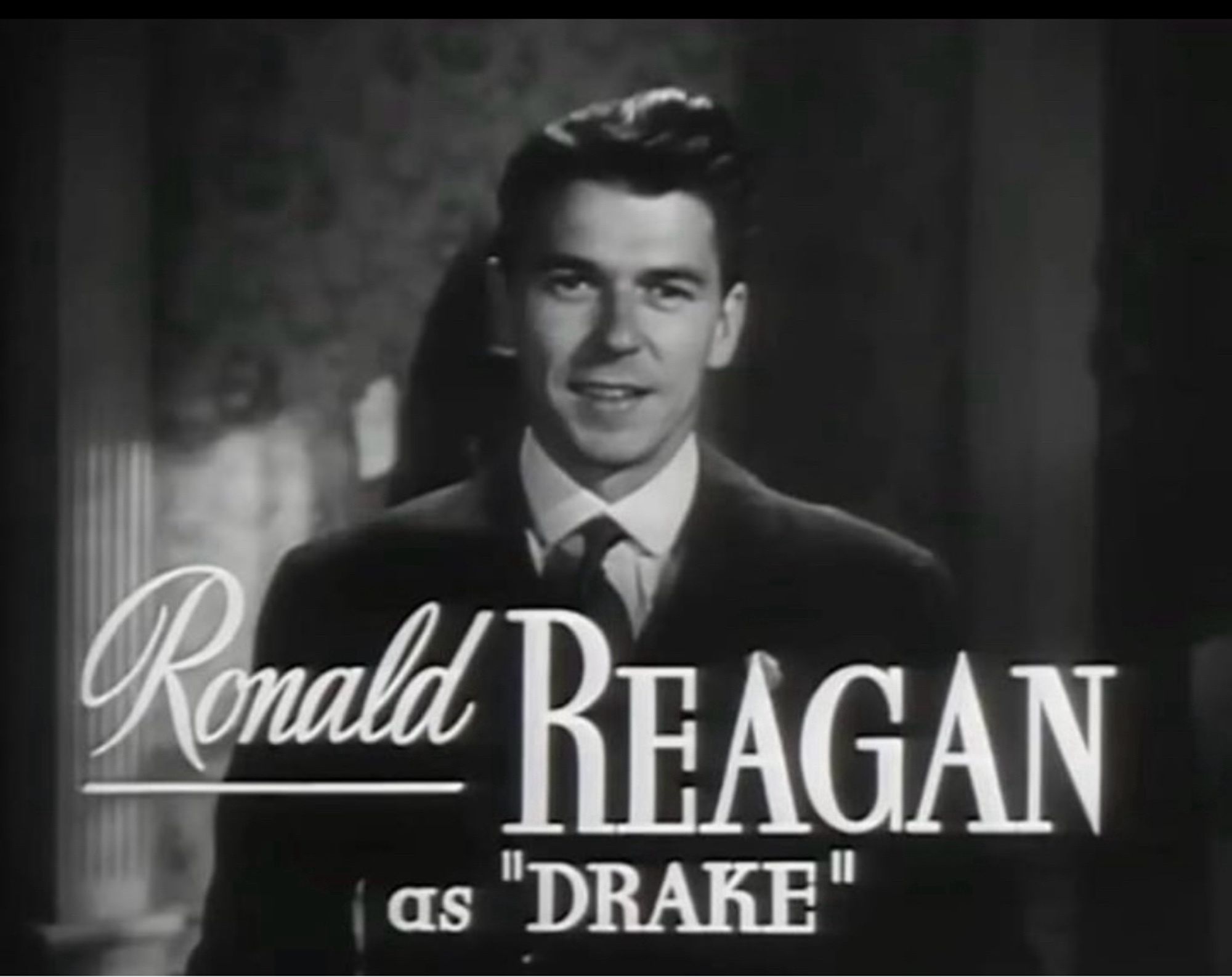 An image from an old movie trailer with a title card over Reagan’s image saying Ronald Reagan as “Drake”