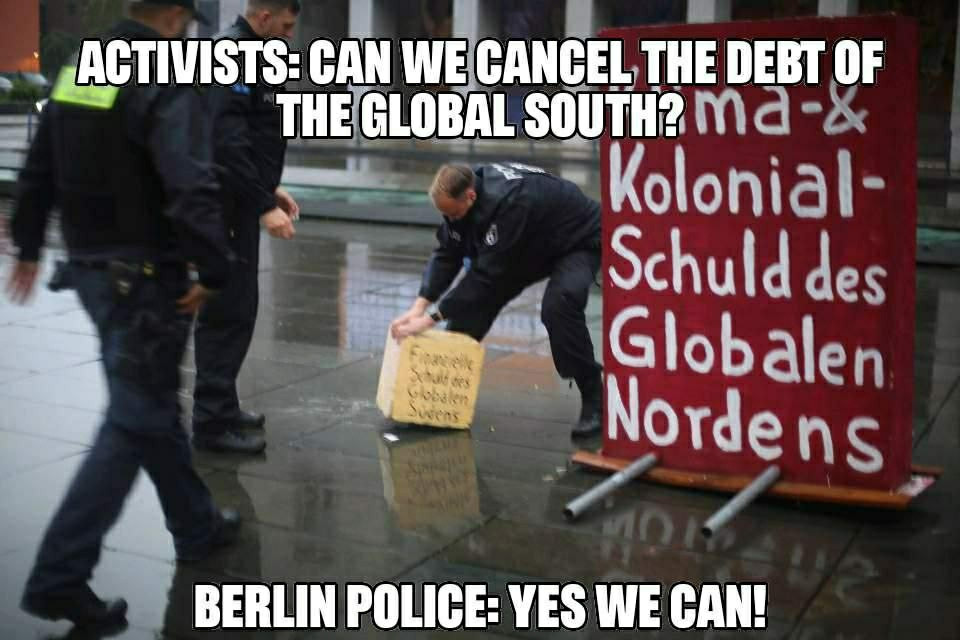 A few police people trying to remove the blockade.
Text:
Activists: can we cancel the debt of the global south?
Berlin Police: yes we can!