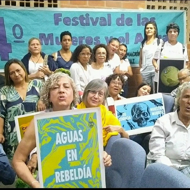 Women holding protest placards. They met for a women and water festival IMF and world bank: cancel the debt of the global south