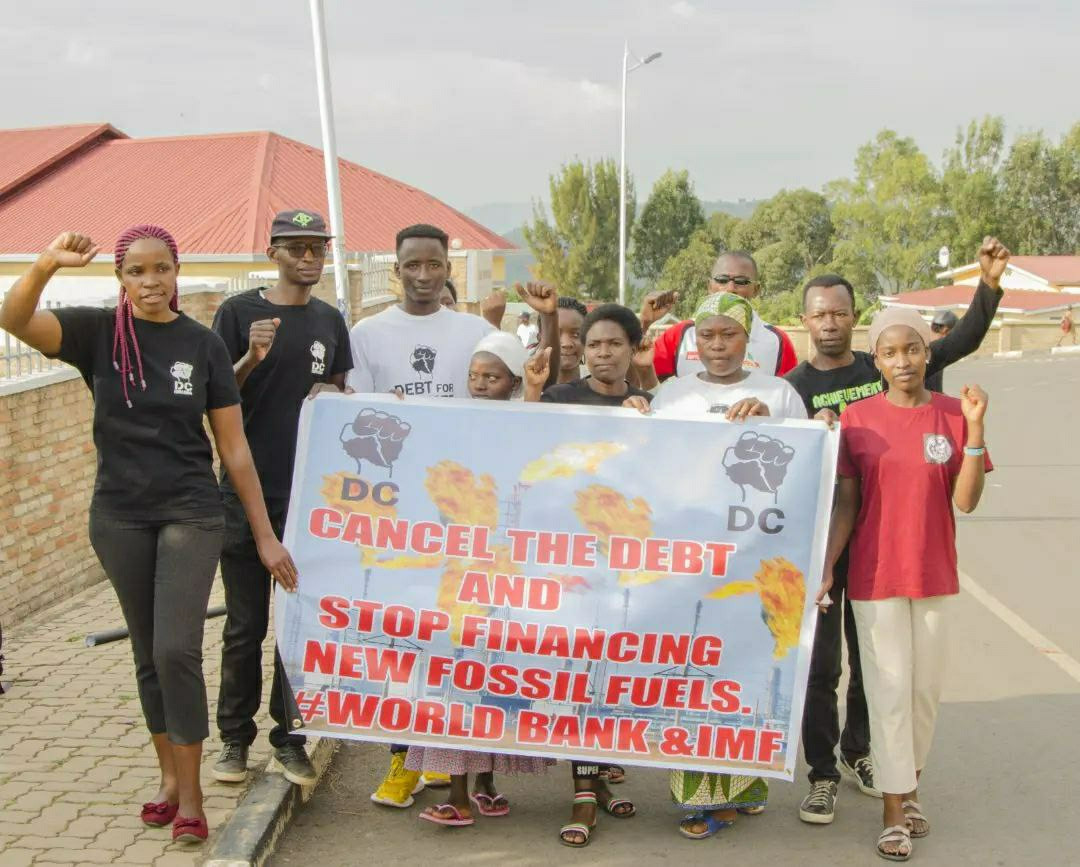 A group of activists marching a street. On there Banner you can read:
"Cancel the debt and stop financing new fossil fuels. World bank & IMG"